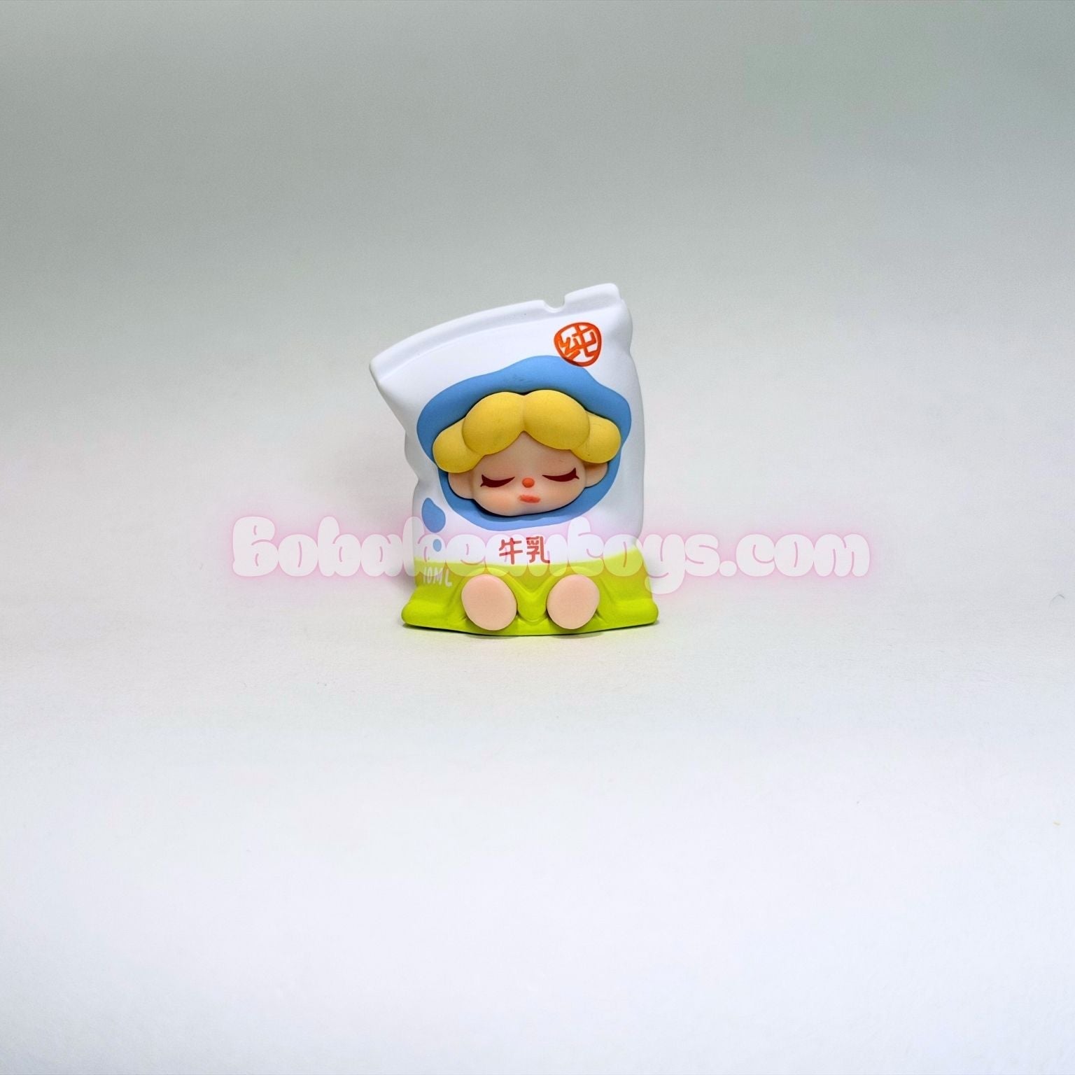 Small figurine of a cartoon character shaped like a bag on a gray background