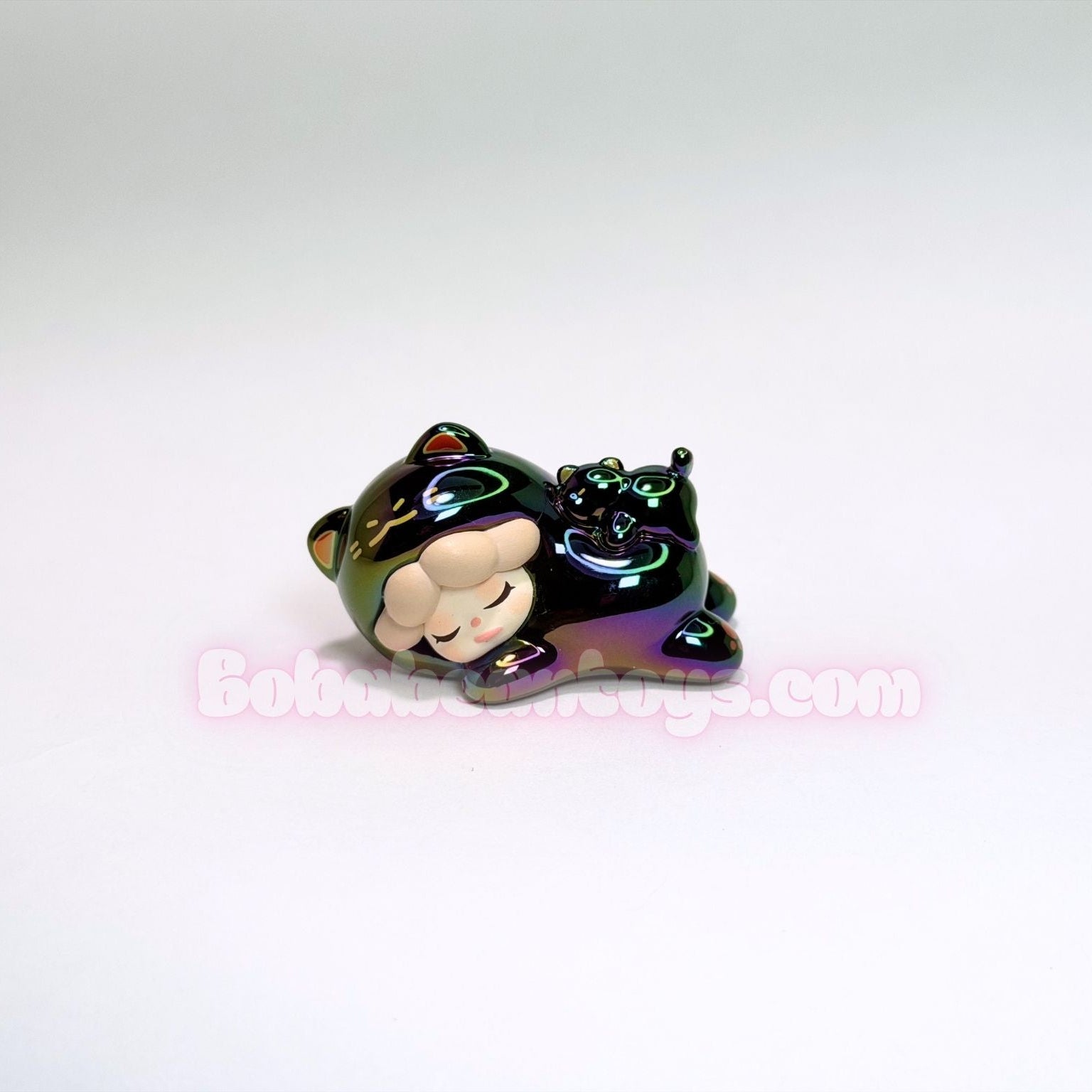 Small figurine of a black cat with a bow tie on a white background