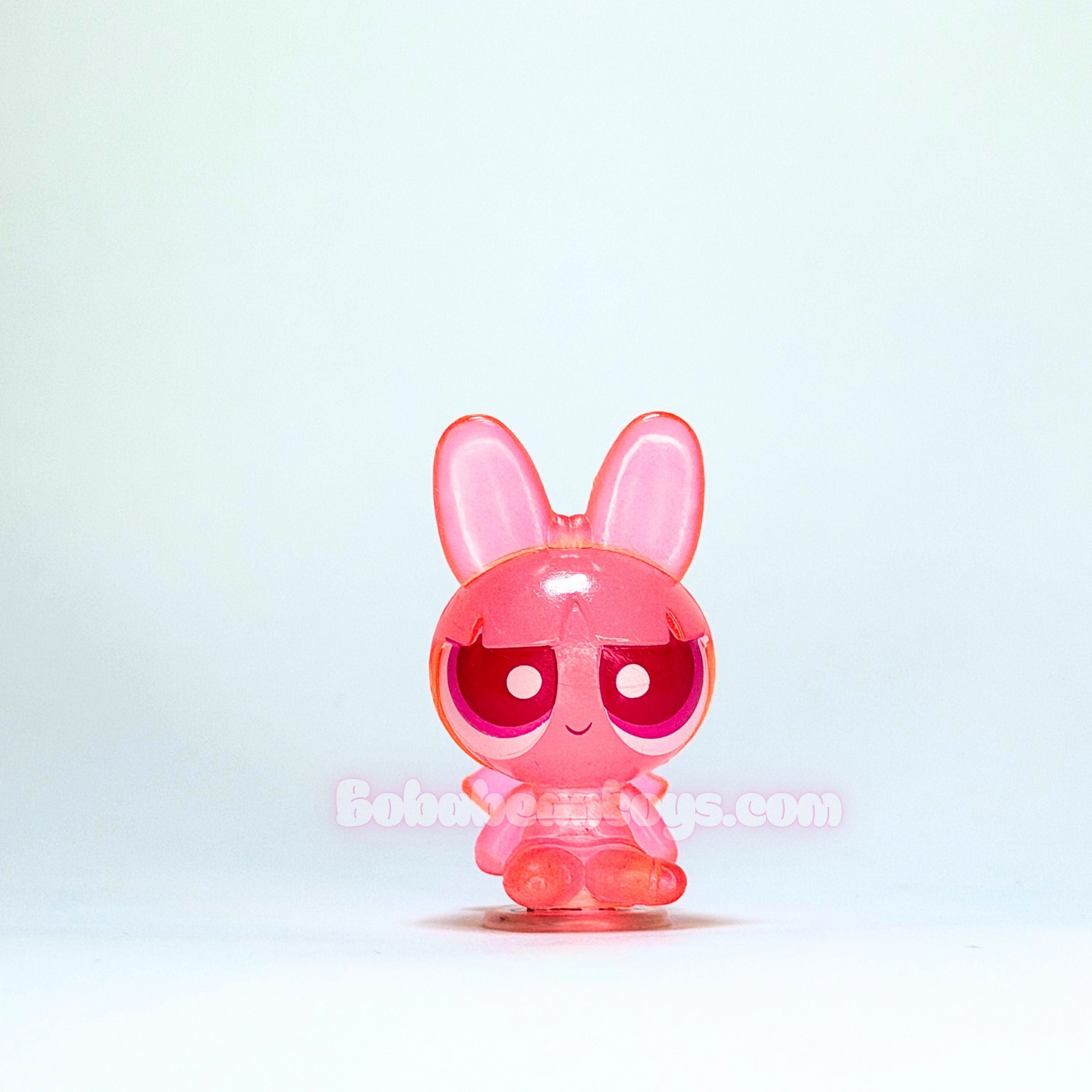 Pink cartoon-like figure with red eyes on a white background