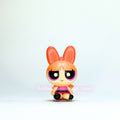 Small figurine with big red bow on a light gray background
