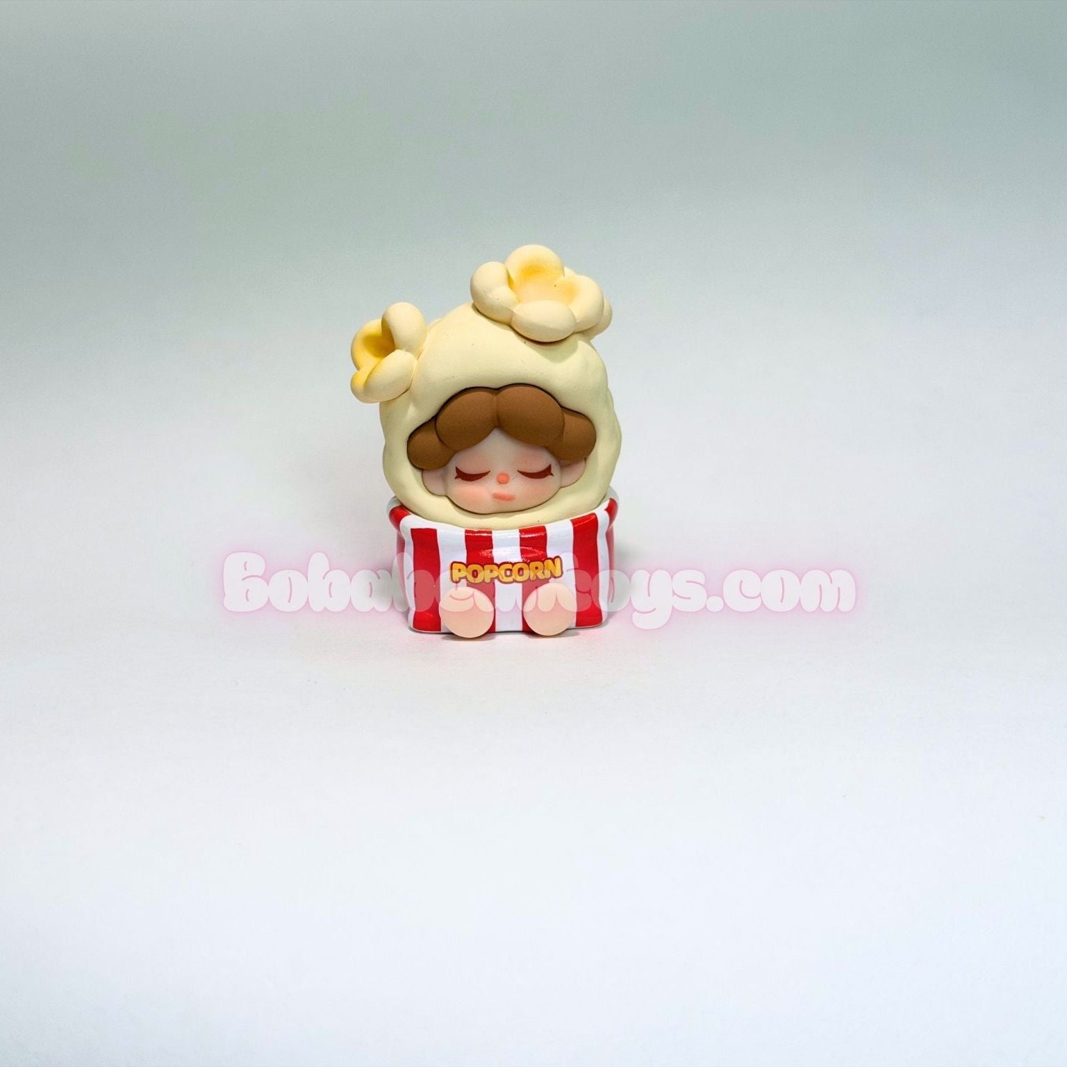Small figurine of a character in a popcorn box on a light gray background