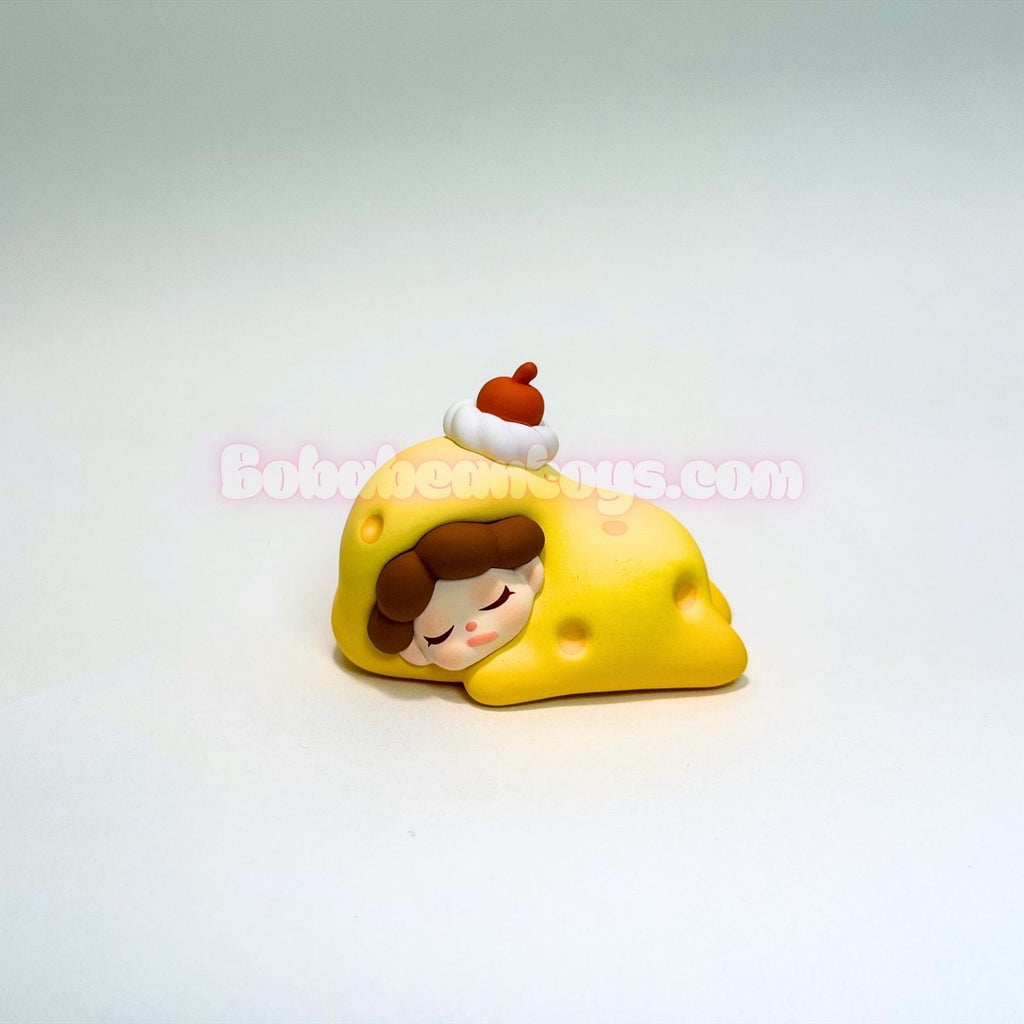 Toy figure of a character sleeping on a yellow pillow with a white background