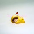 Toy figure of a character sleeping on a yellow pillow with a white background