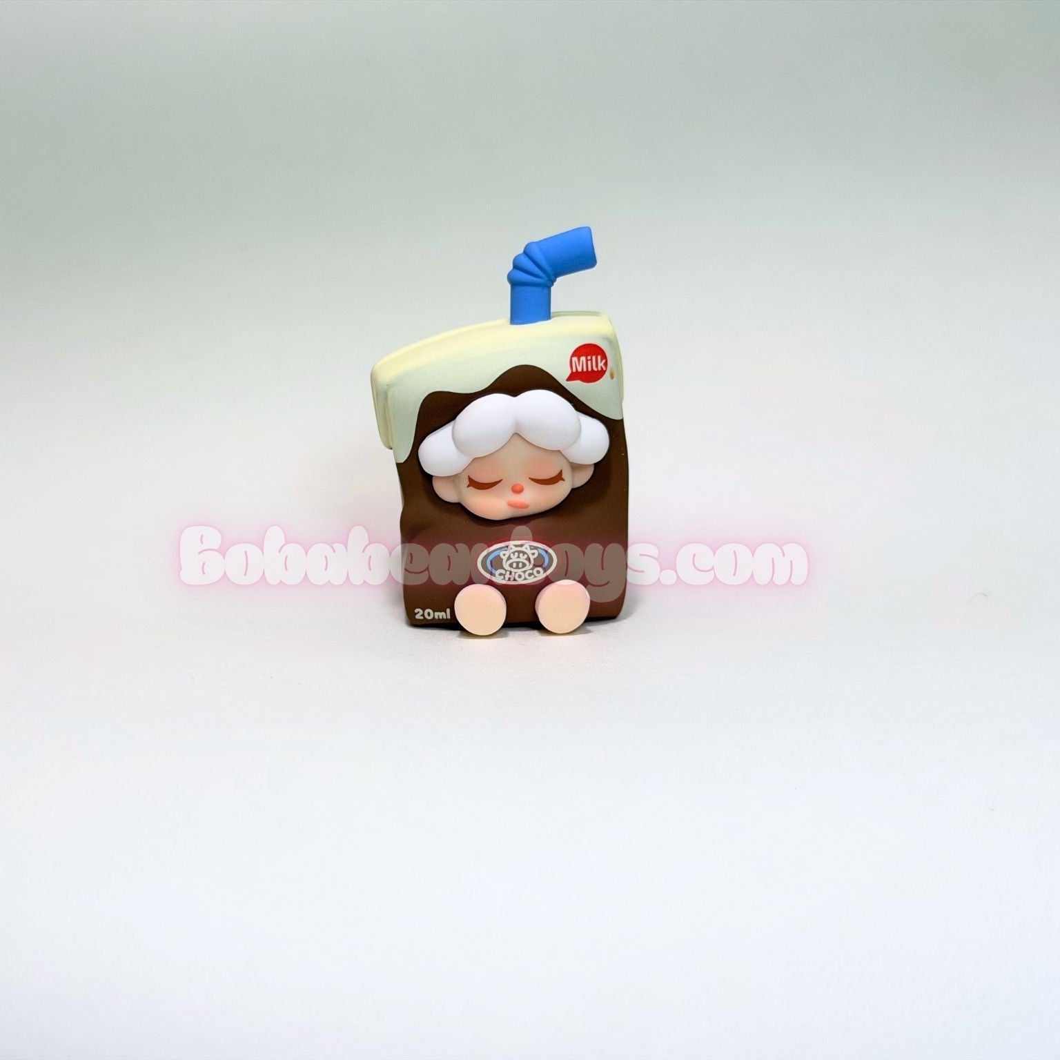 Toy figure of a character in a brown outfit with a blue straw on a light gray background