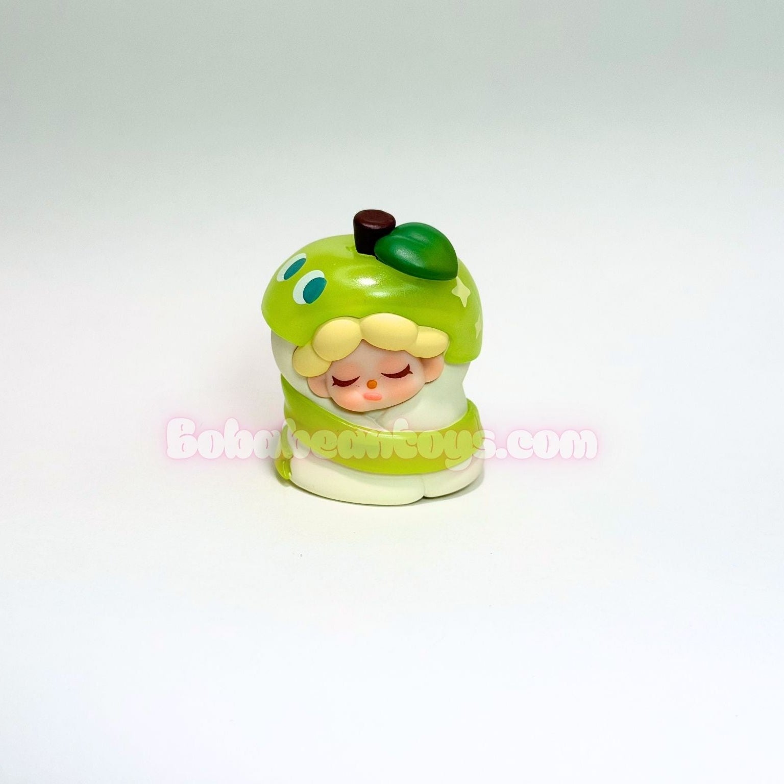 Small figurine of a character inside an apple on a white background