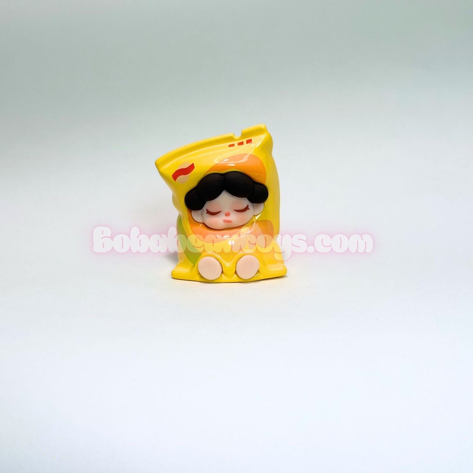 Small figurine of a character as a bag of potato chips on a white background
