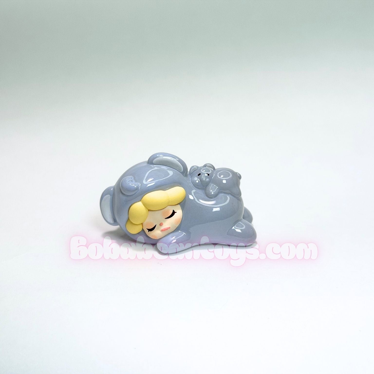 Toy figure of an elephant character with a gray outfit and yellow head on a white background