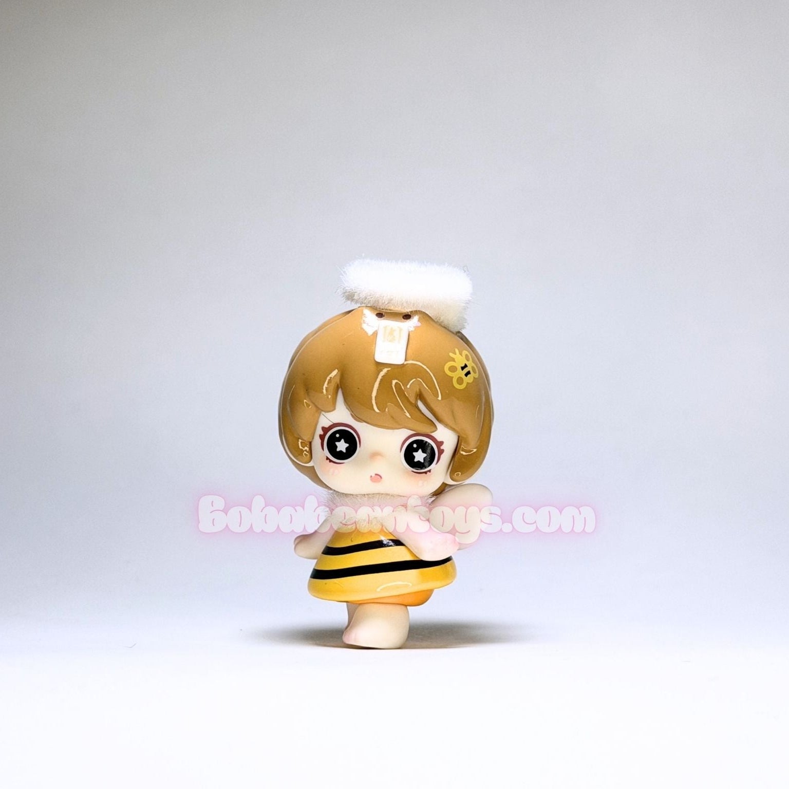 Toy figure with bee costume on a plain background