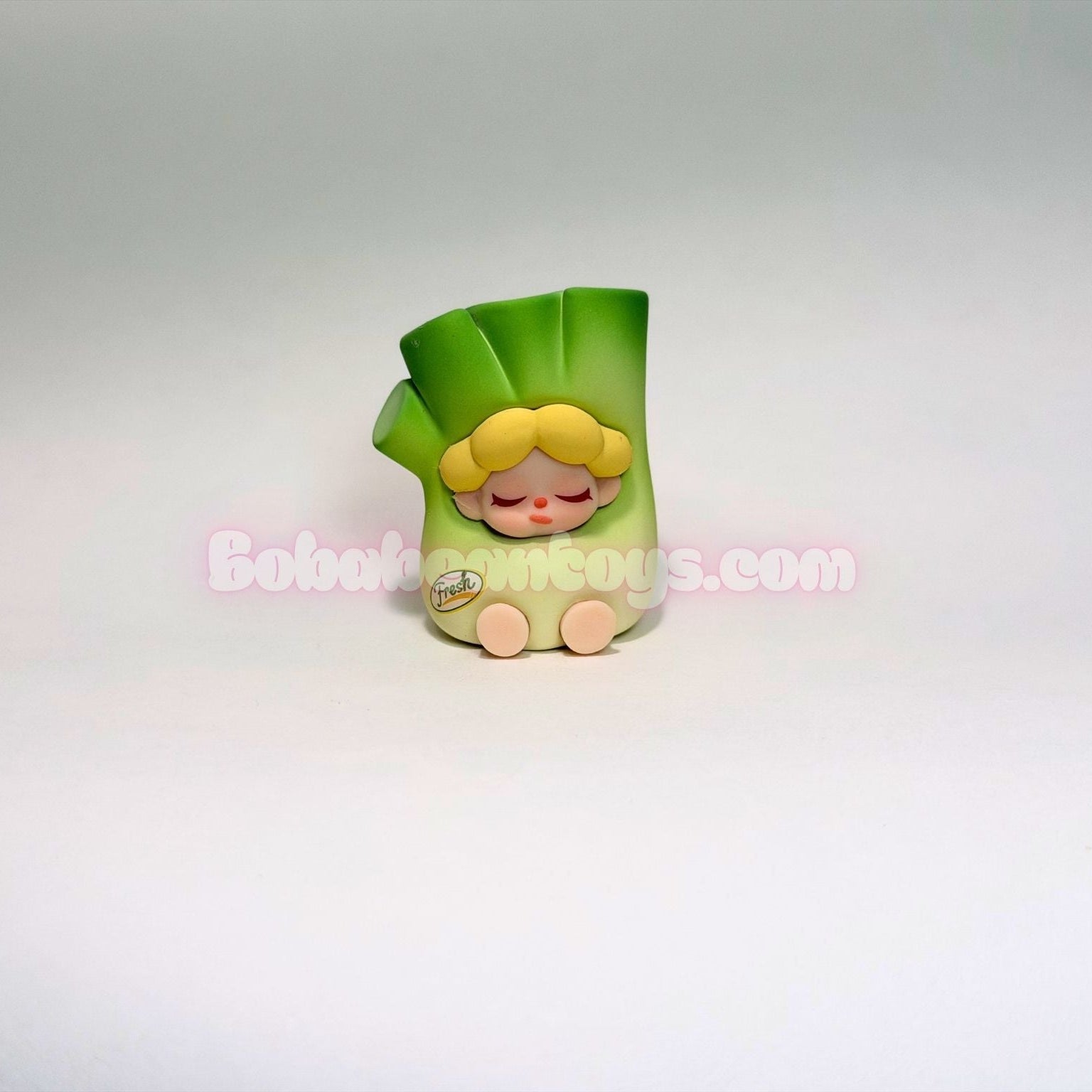 Toy figure of a character with green hair dressed as a green onion on a white background