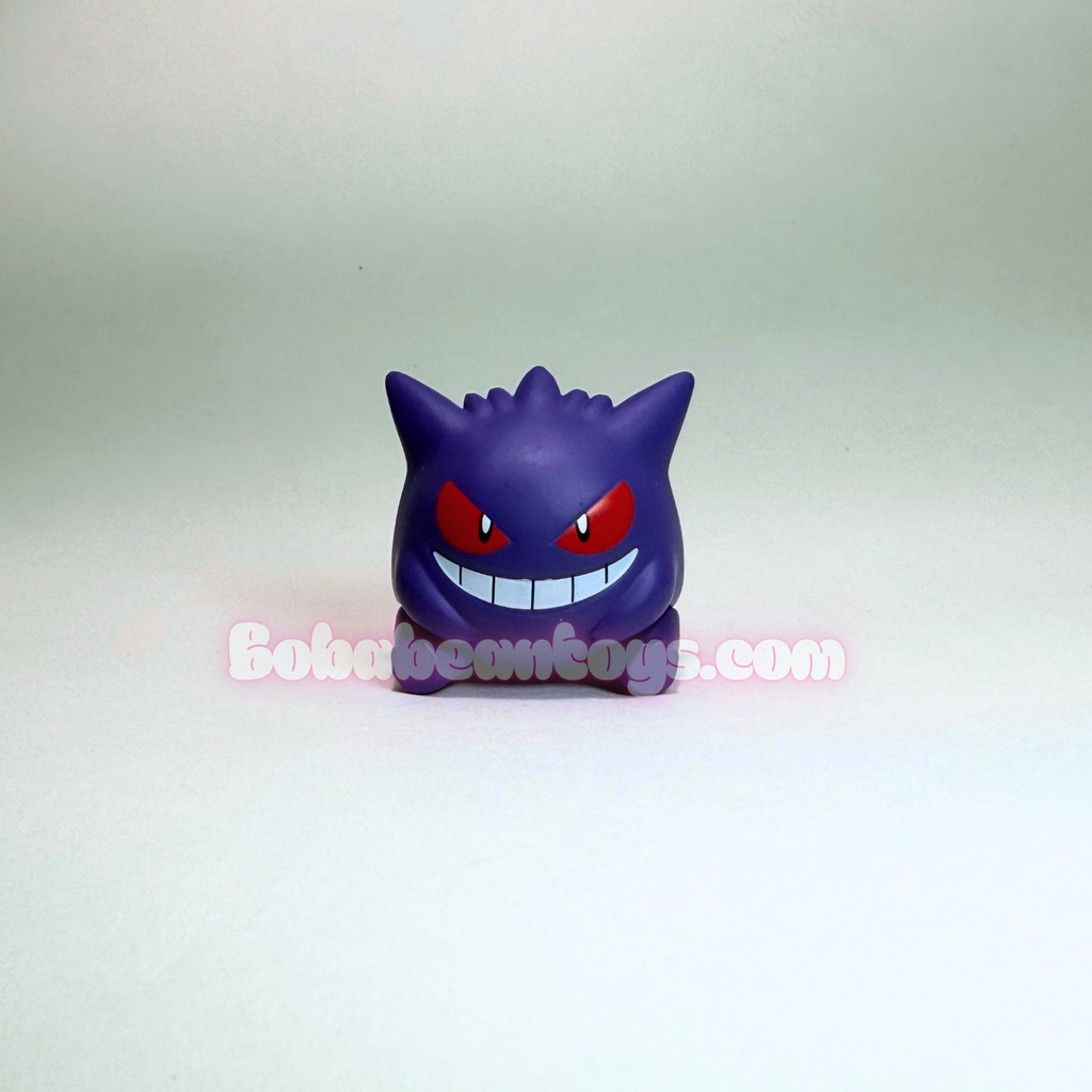 A small purple Gengar toy figure with red eyes and a wide grin, photographed against a plain light gray studio background. A semi-transparent 'BobbeanToys.