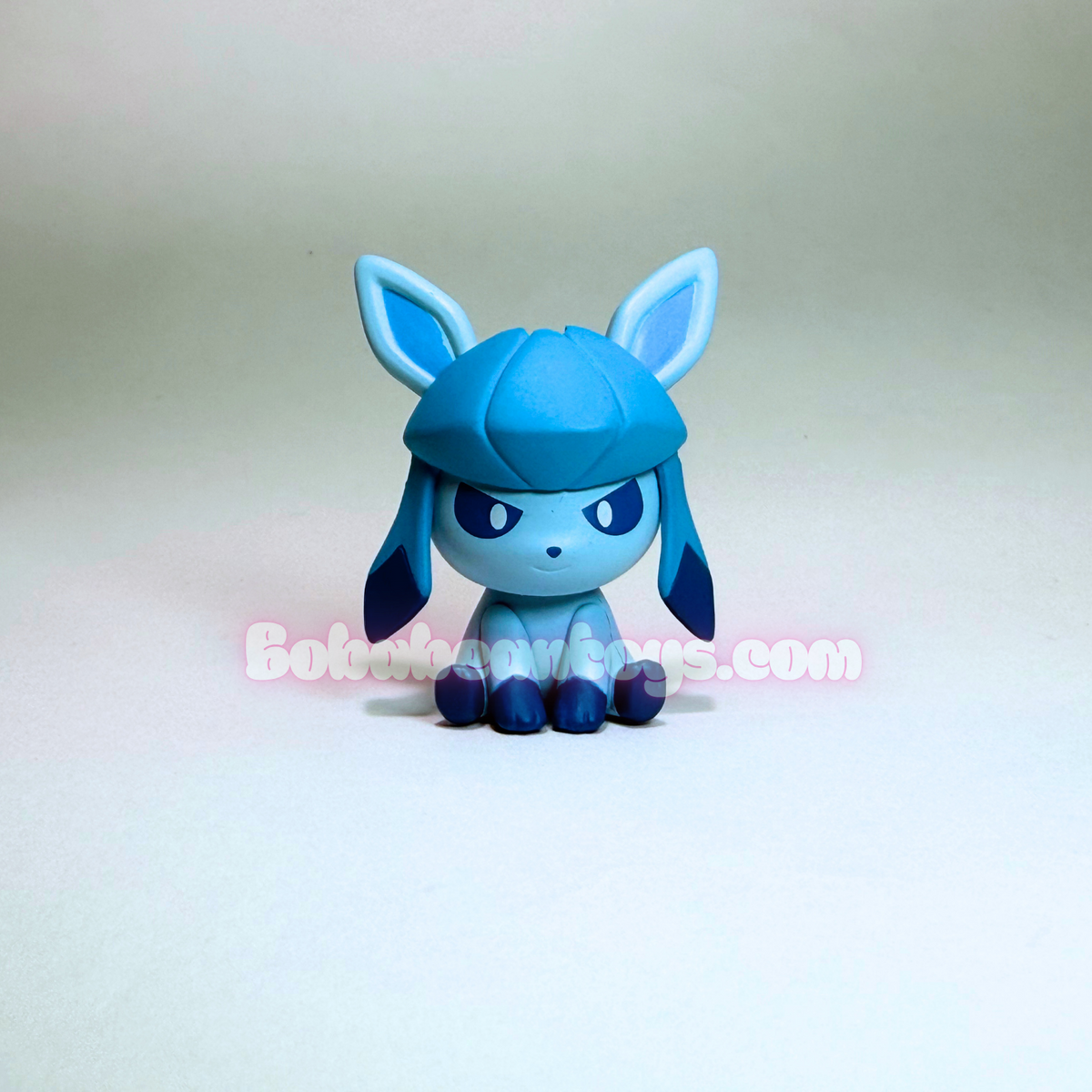 A small blue and light blue character figurine with pointed ears and dark blue feet, centered on a plain light background. A faint 'Bokoblin Store.