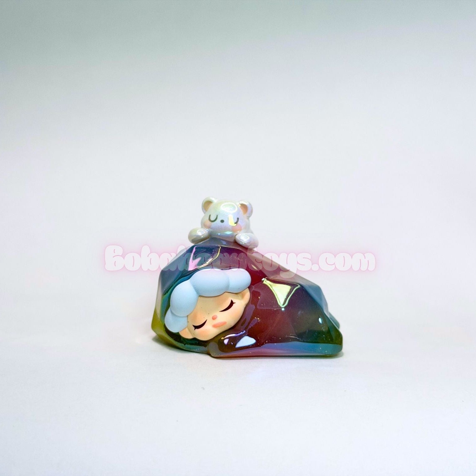 Colorful faceted figurine of a character with a small animal on a white background