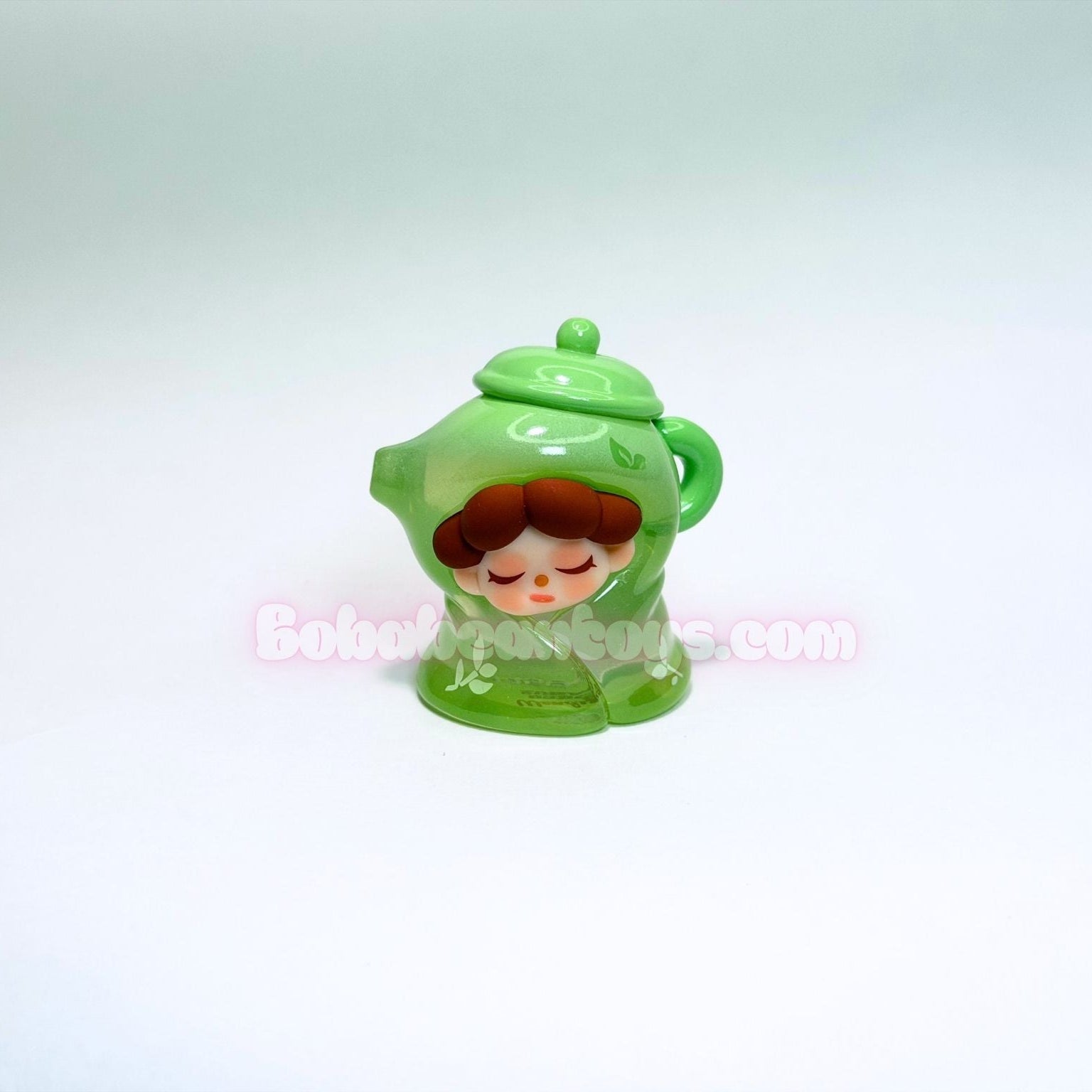 Green character-shaped like a tea pot on a white background