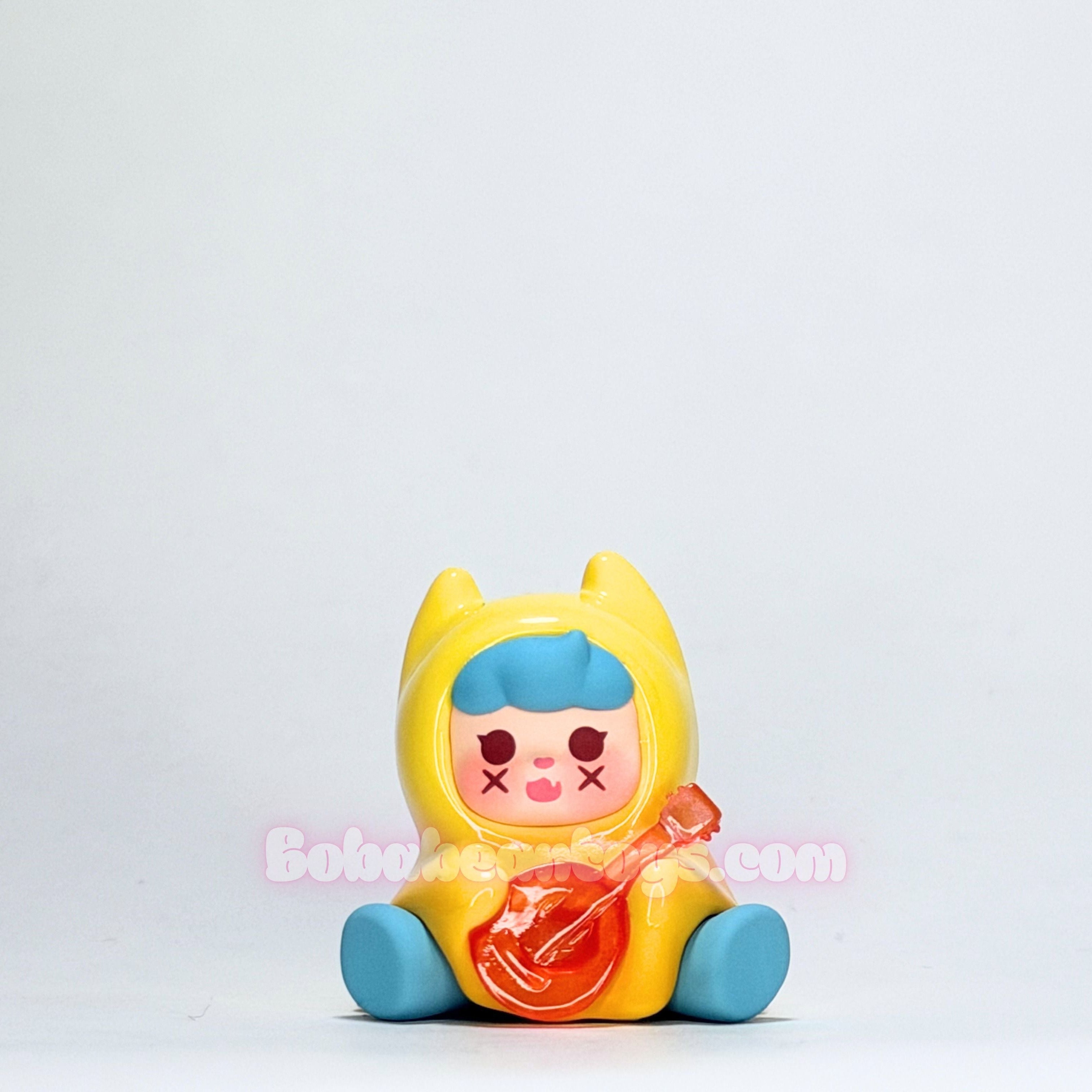 Colorful toy figure with a blue hat and red candy on a light gray background