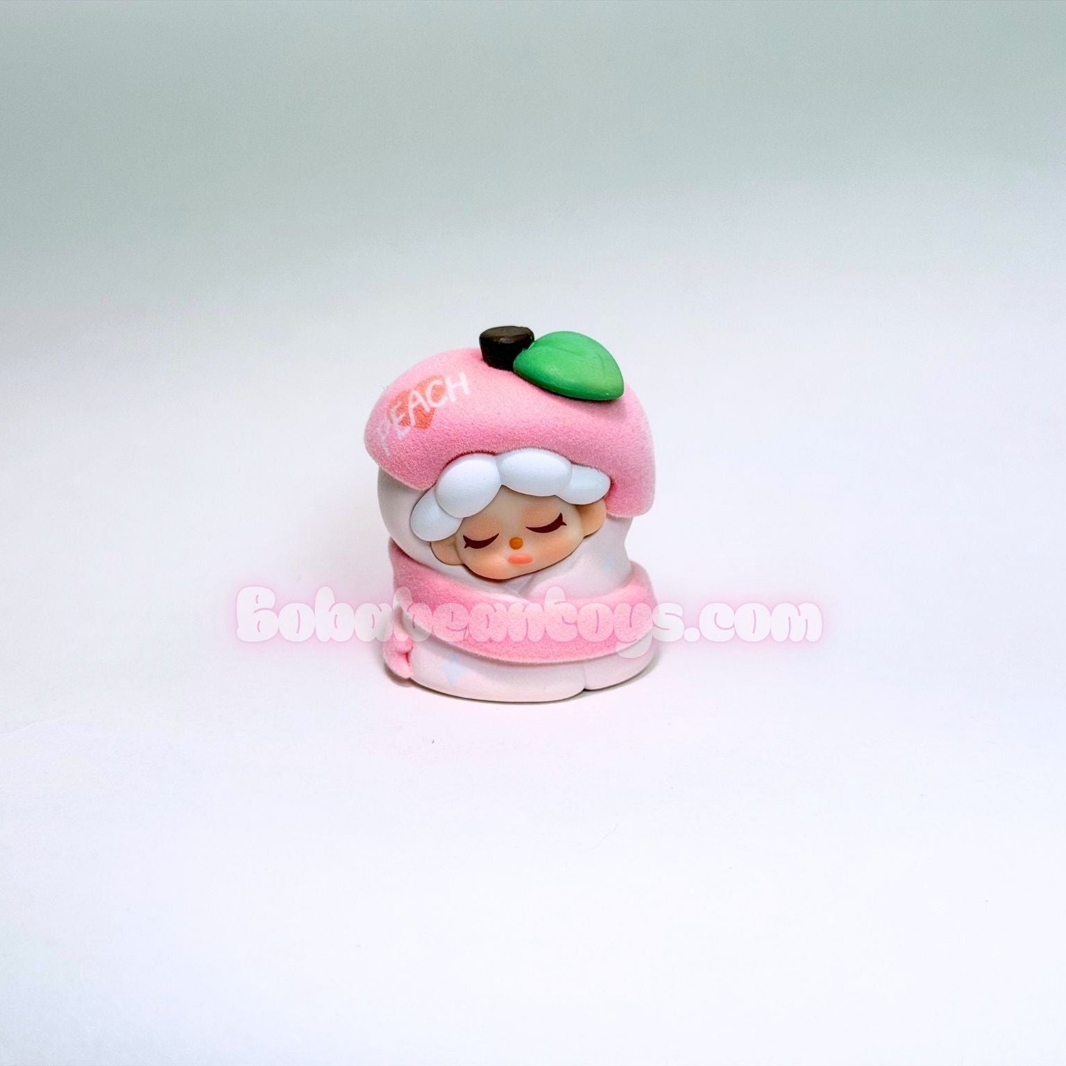 Small figurine of a character with a pink hat and white hair on a light gray background