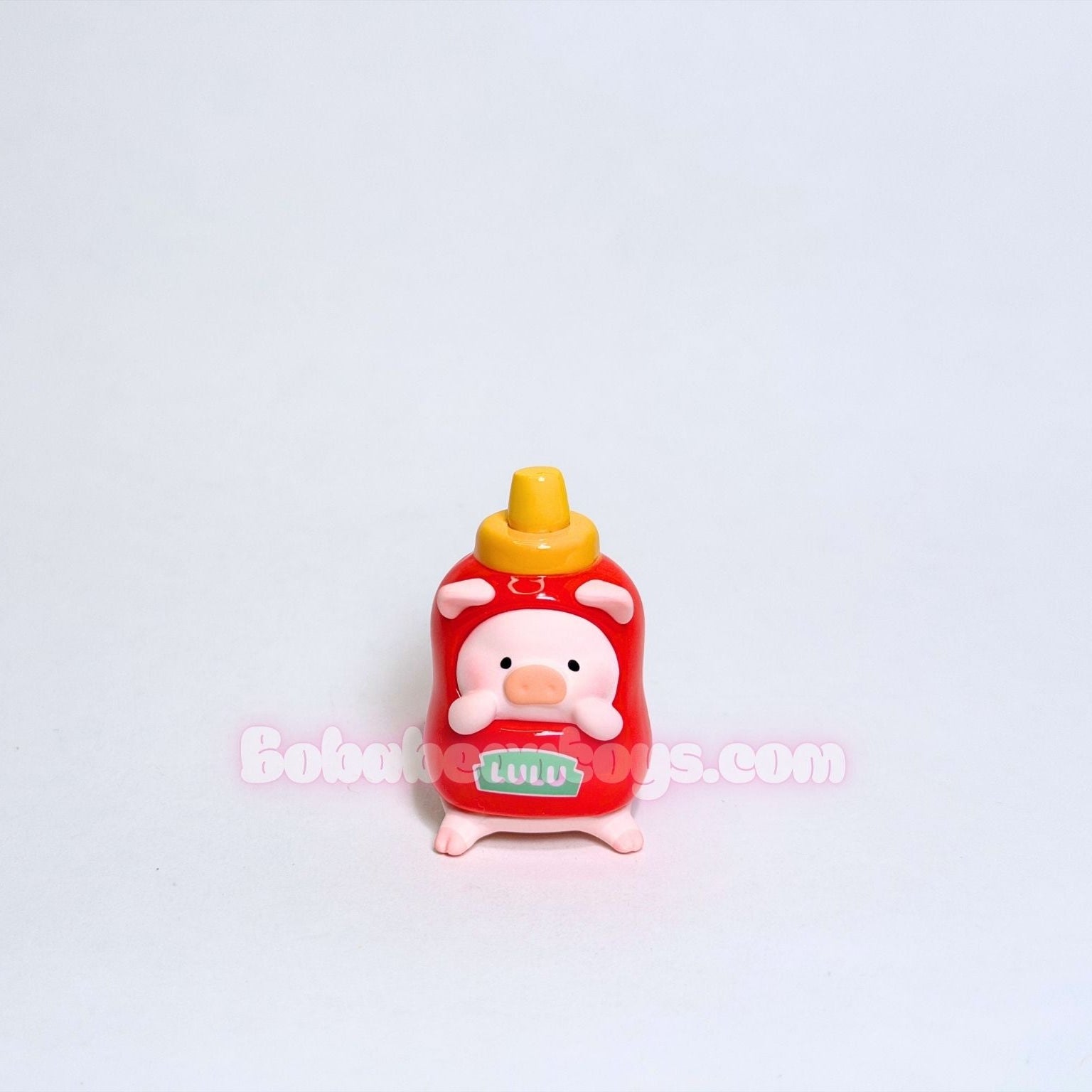 Small toy resembling a ketchup bottle with a cartoon character on a light gray background