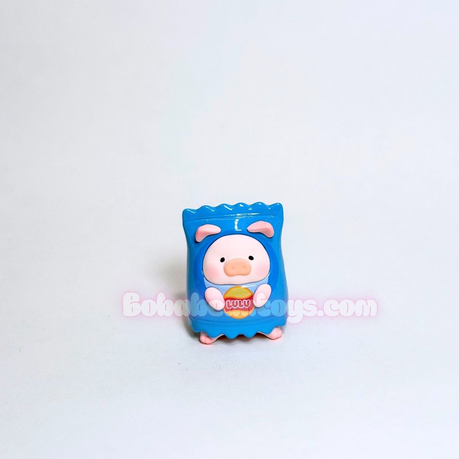 Small blue toy figure with a pig design on a light gray background