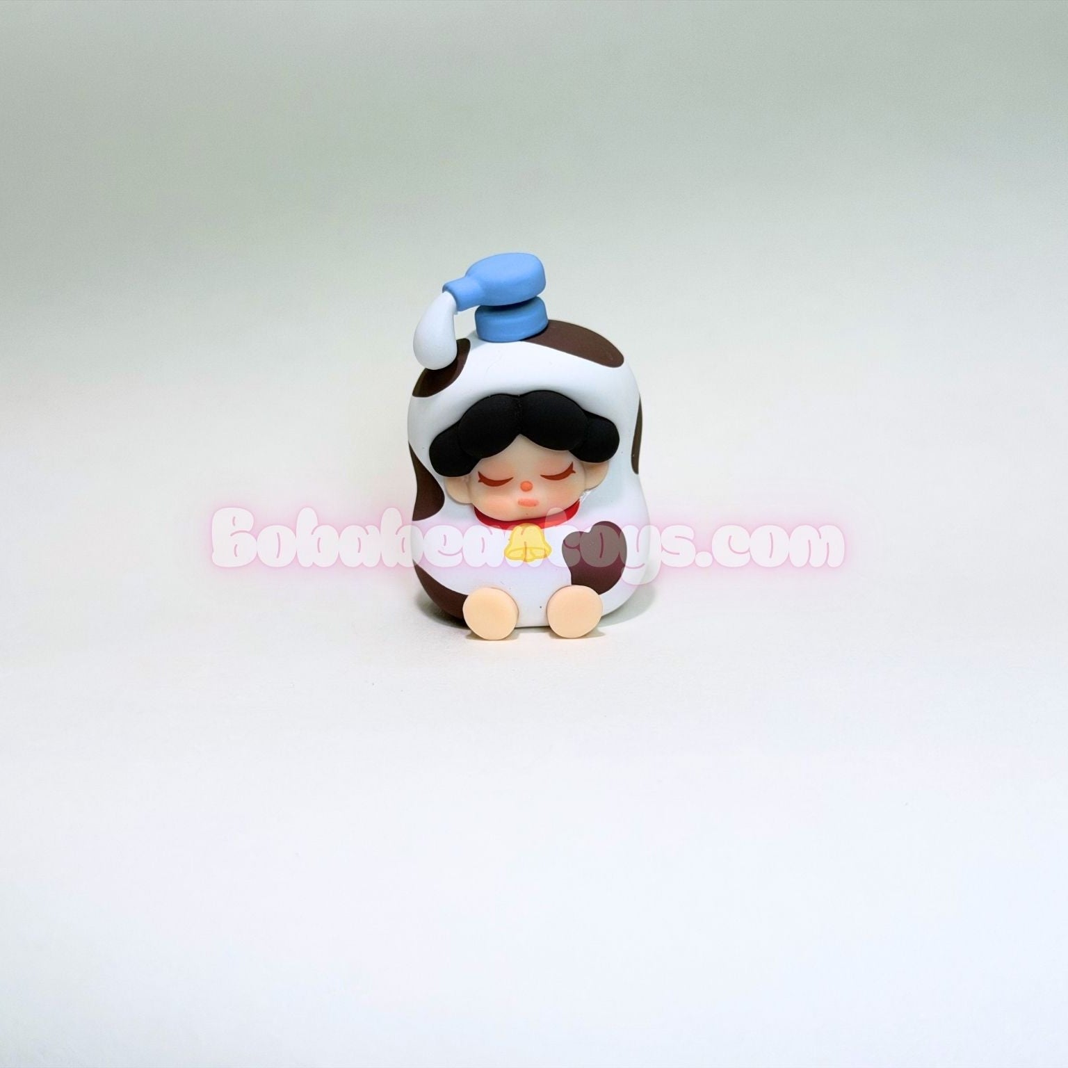 Small figurine of a shampoo bottle on a light gray background