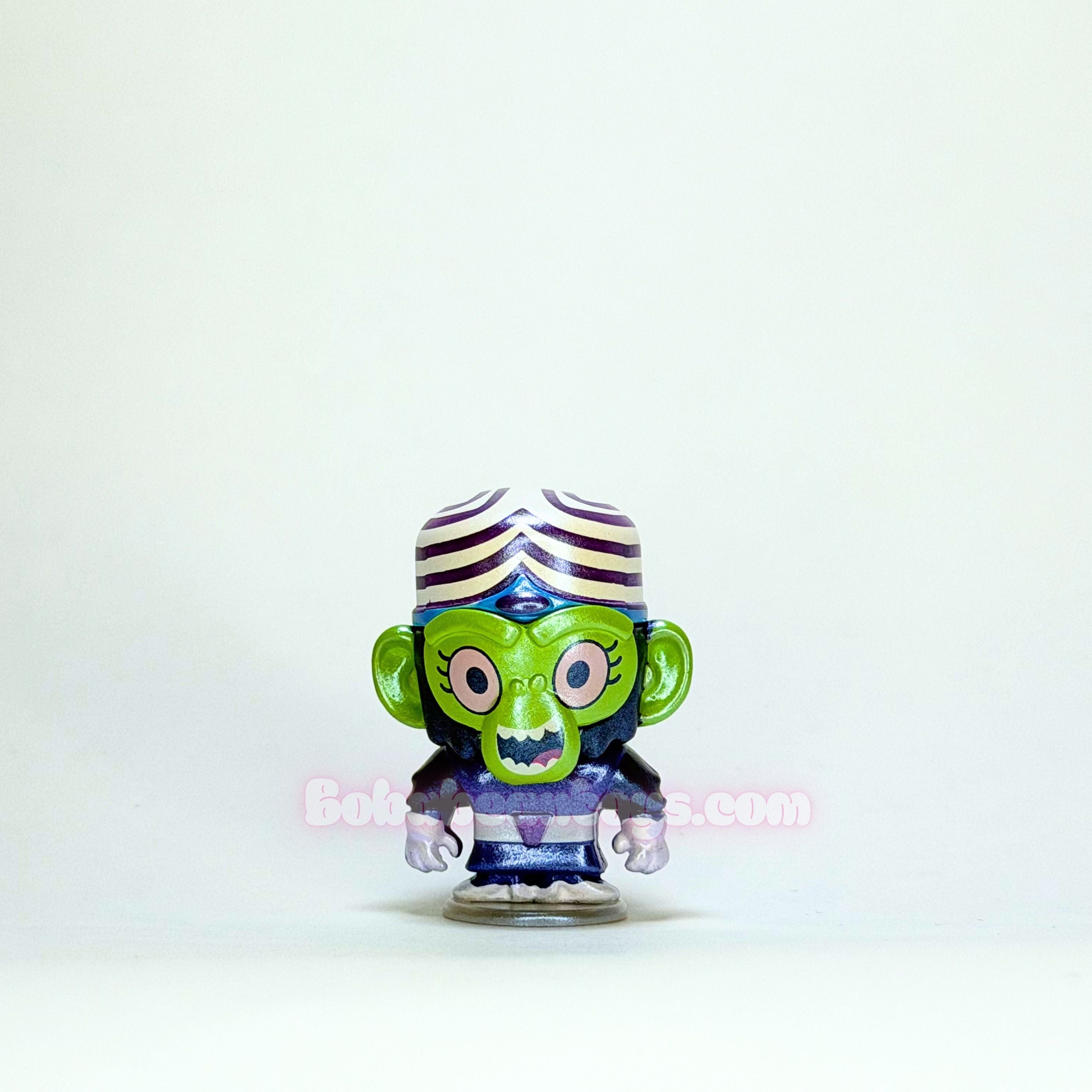 Toy figure with green face and striped hat on a white background