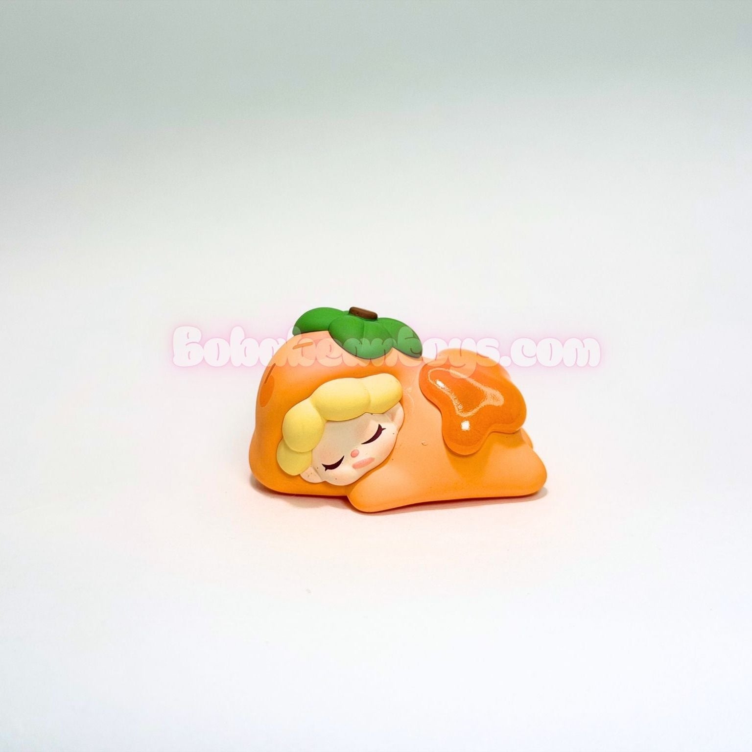 Small figurine of a character as a persimmon on a white background