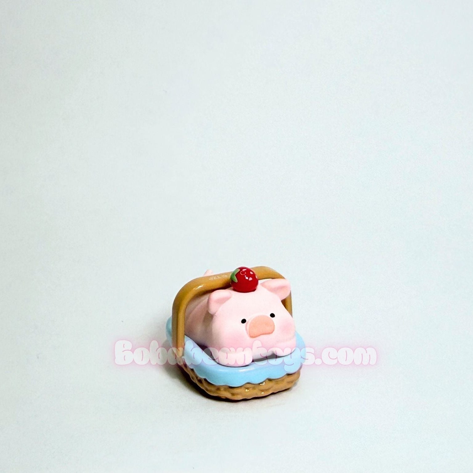 Small pink piggy resting inside a picnic basket on a white background.
