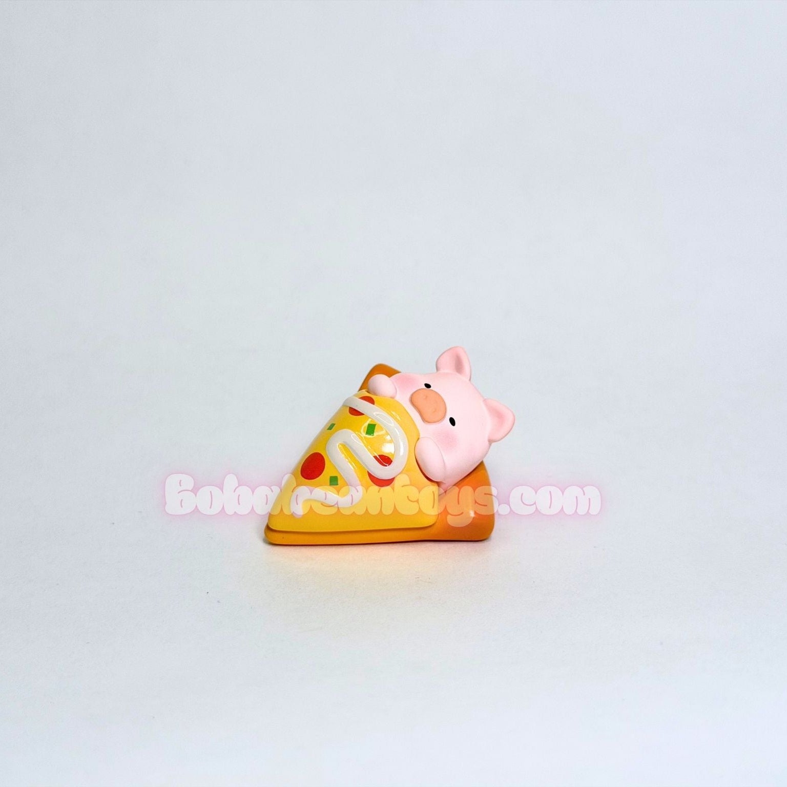 Small pig laying on a slice of pizza on a light gray background