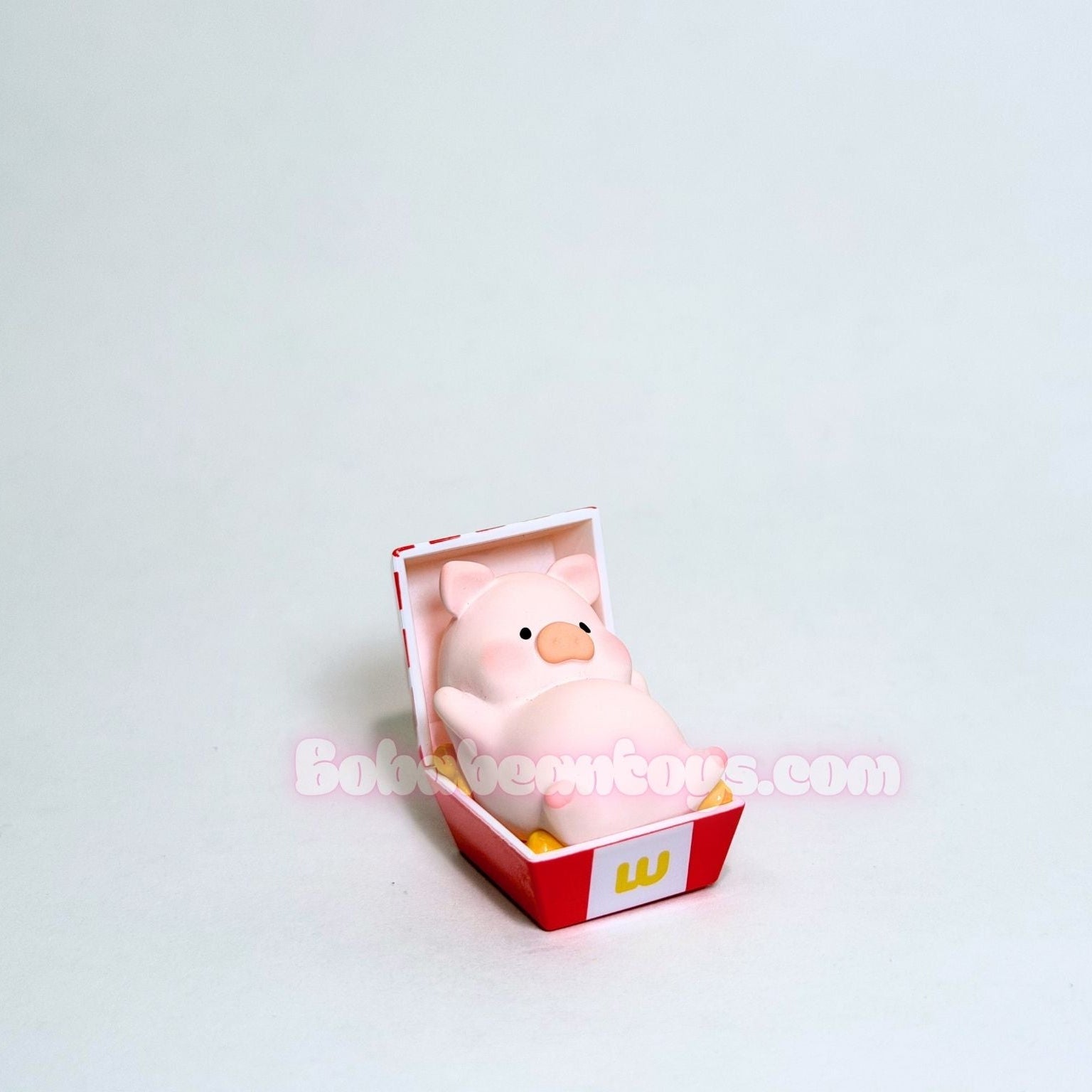 Pink piggy laying inside a red and white chicken box with a white background