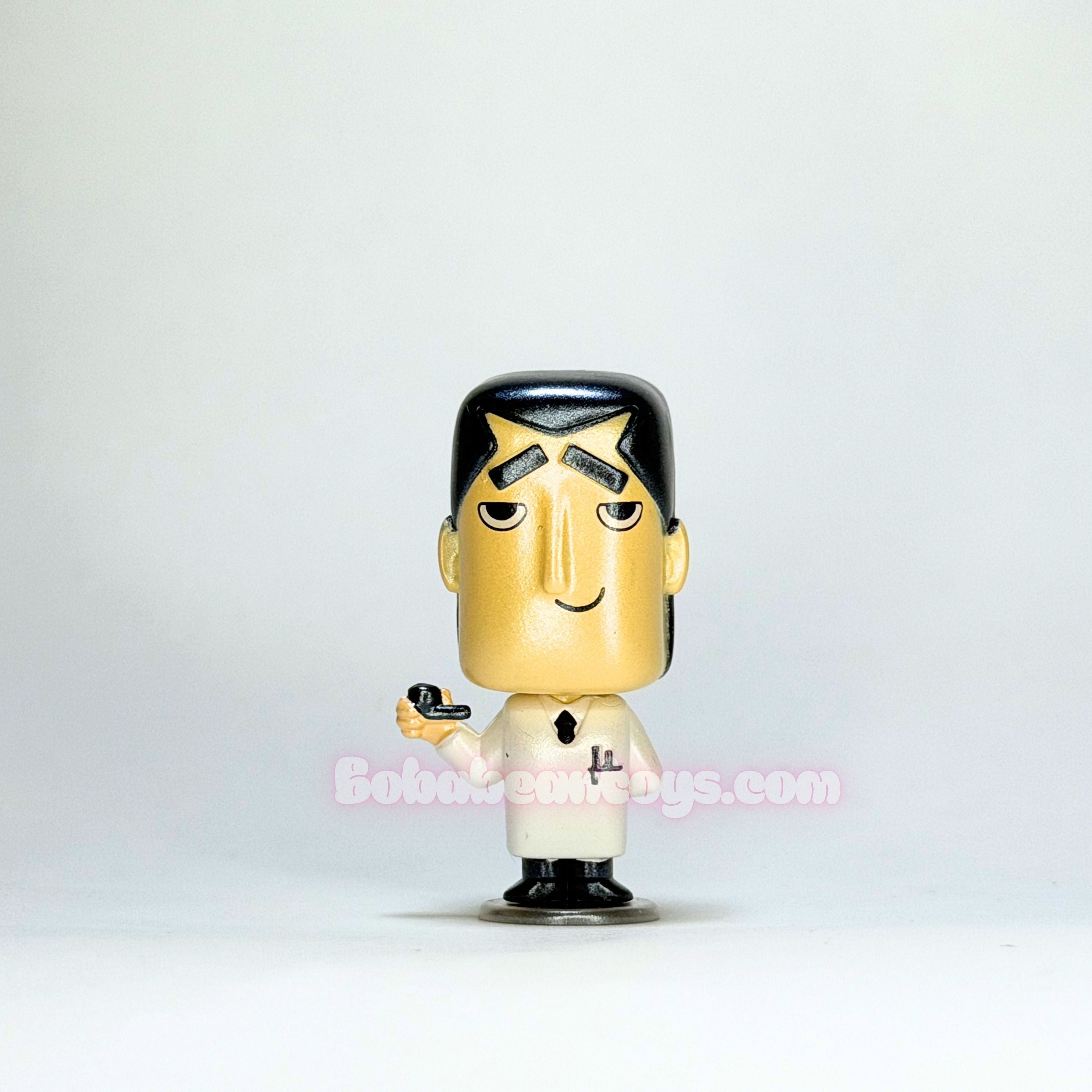 Small figurine of a character with a white shirt and black shoes on a light gray background