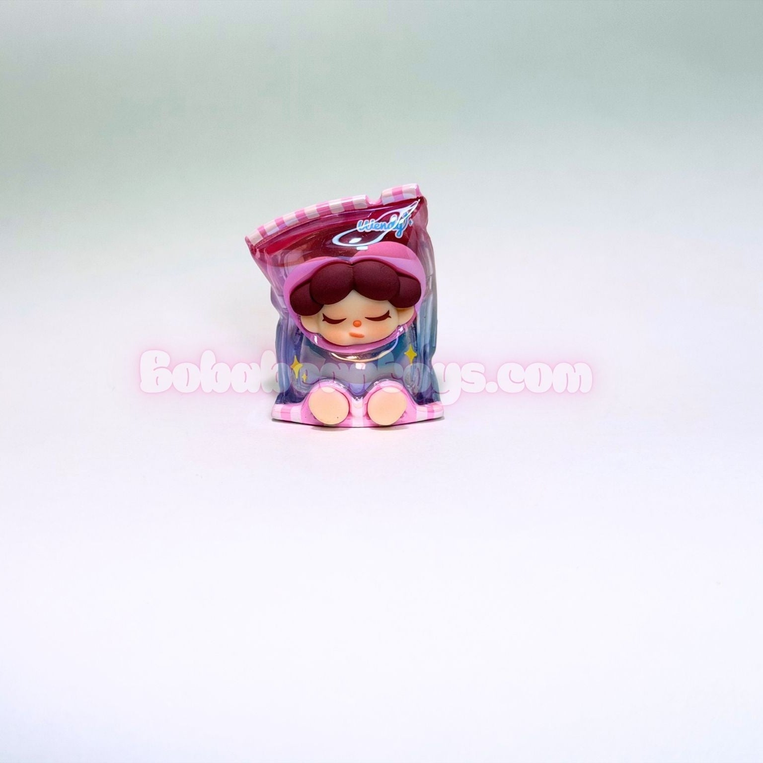 Small figurine of a bag of candy on a light gray background