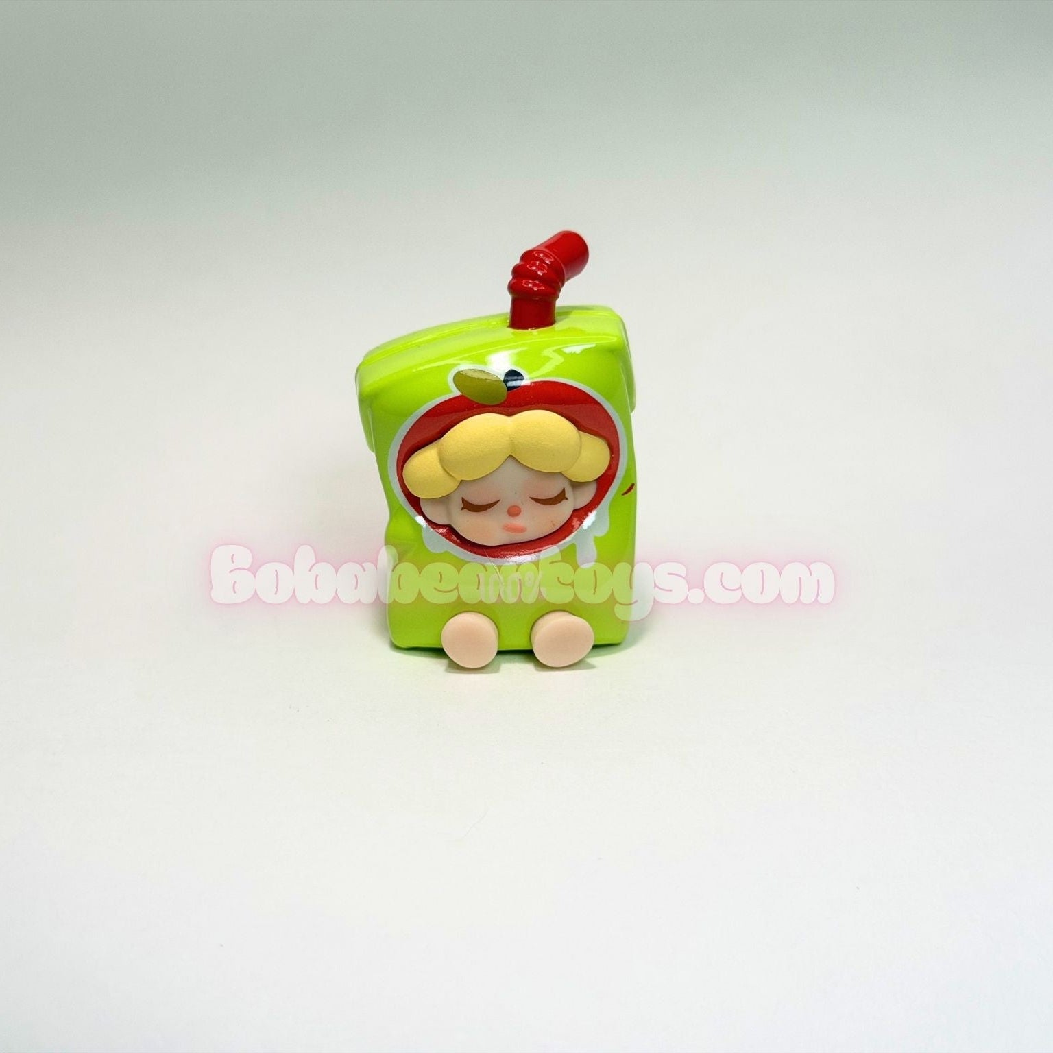 Toy figure of a character with a green body and red hair on a white background
