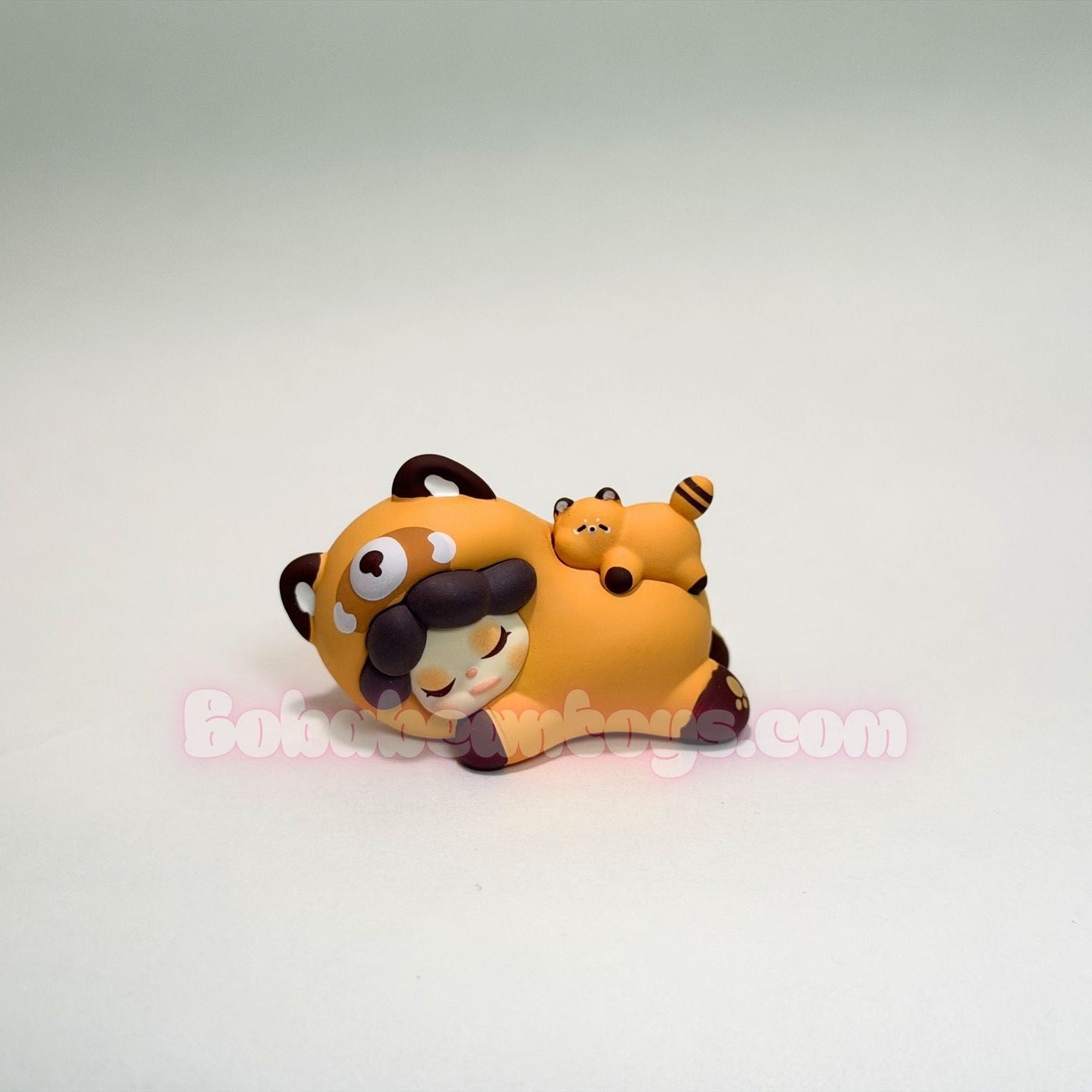 Toy figure of a red panda on a white background