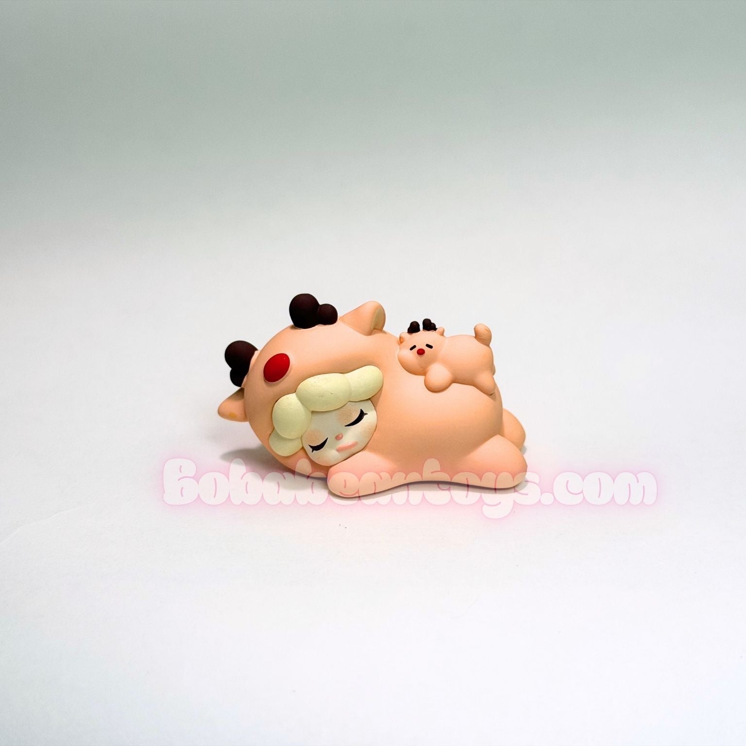 Toy figure of a reindeer hugging on a white background