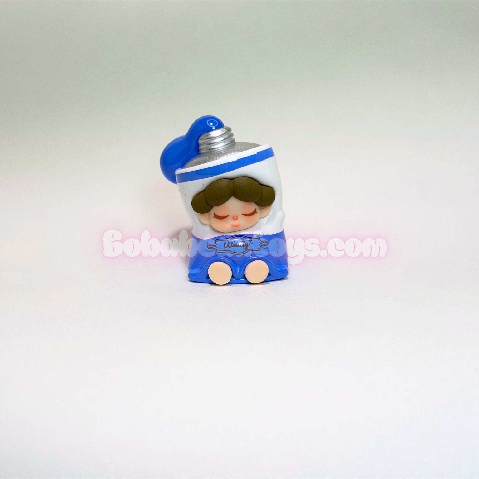 Small figurine of a character of a blue tube of paint on a white background