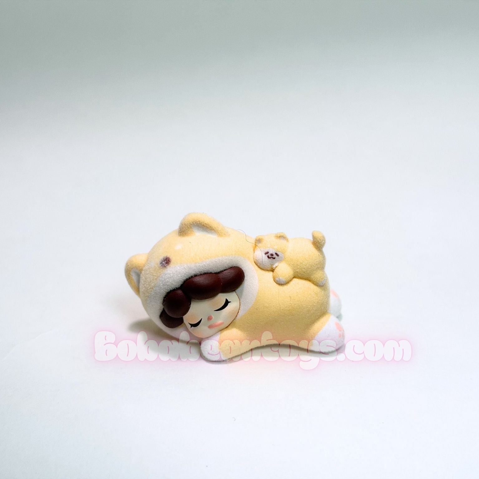 Small yellow shiba inu figurine with a white background