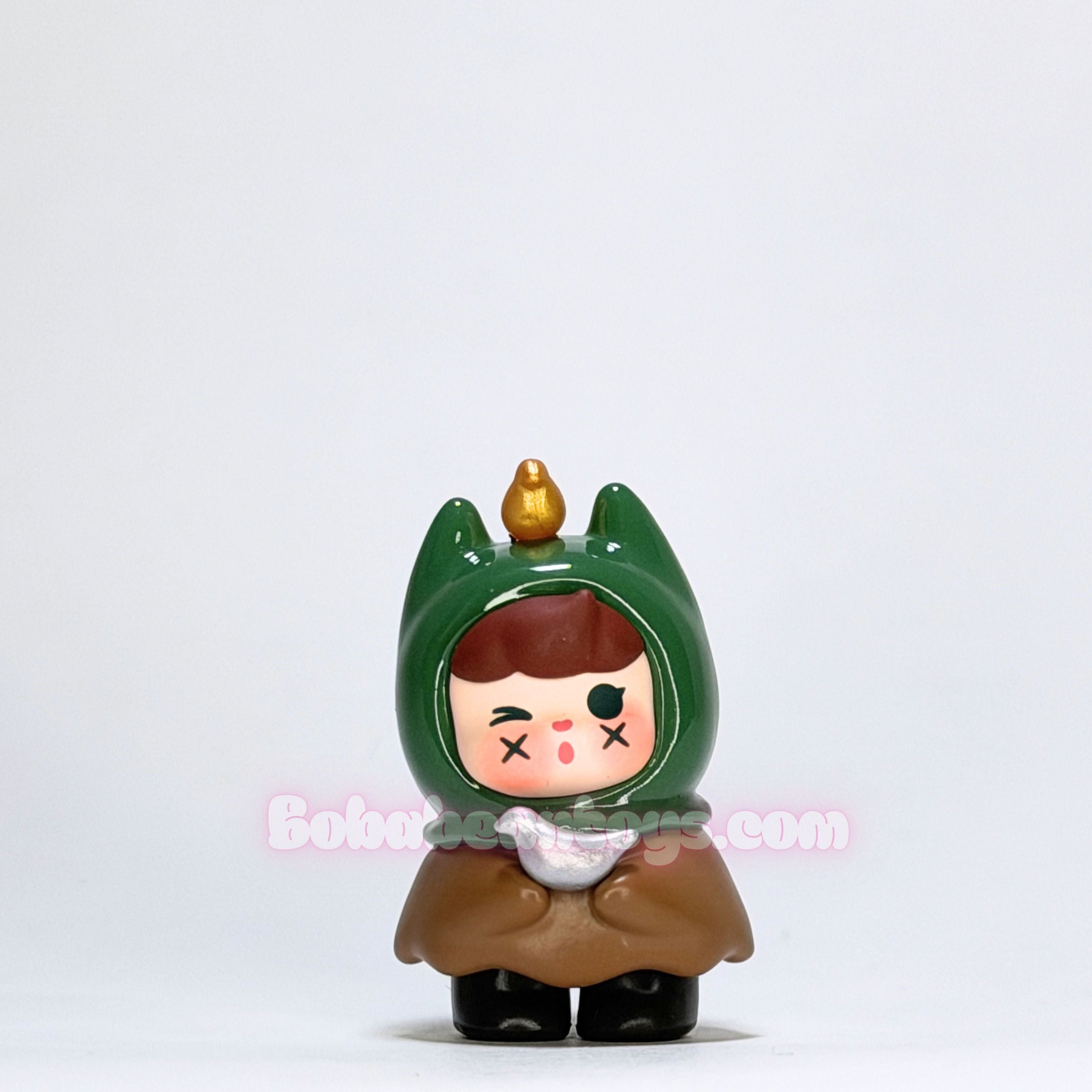 Small figurine with green hood and brown outfit on a white background