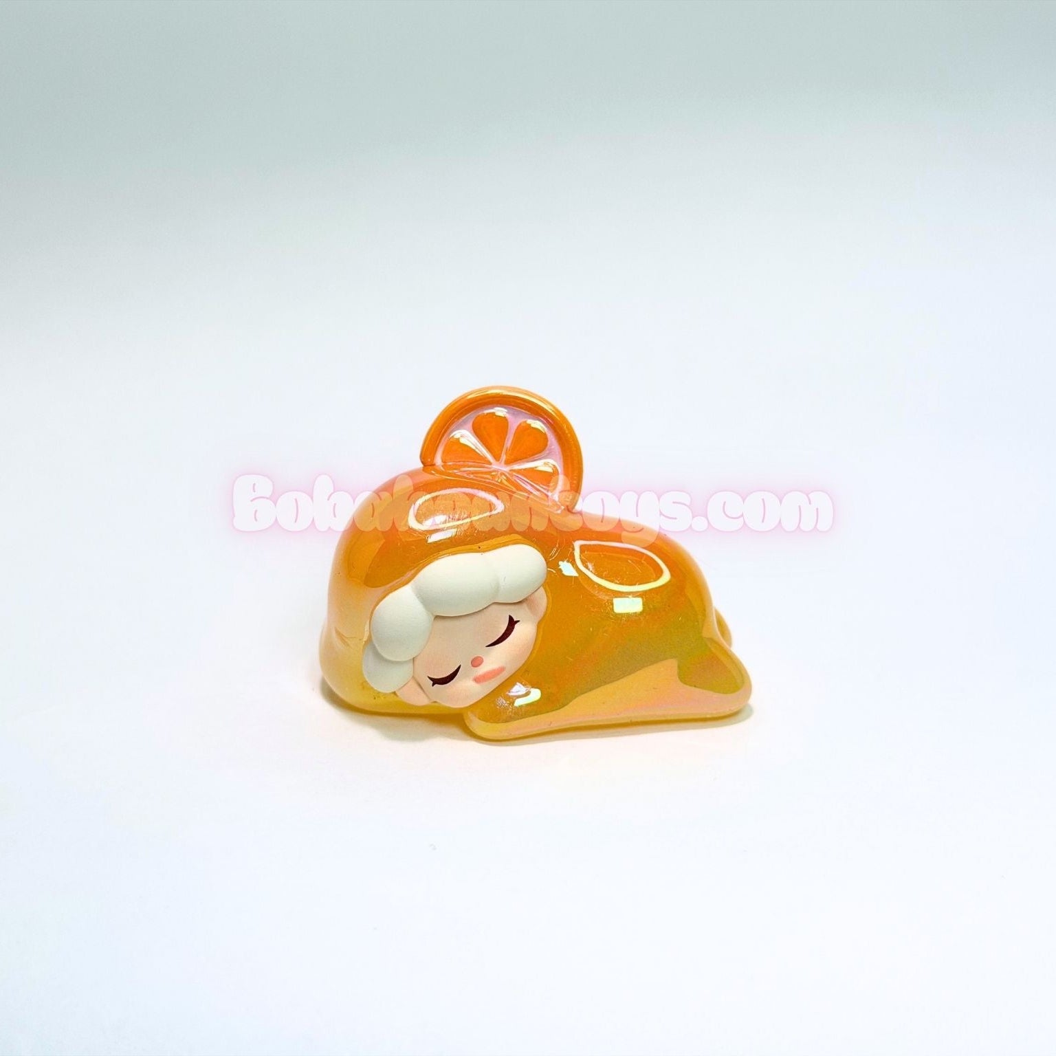 Small figurine of a character with an orange slice on a white background