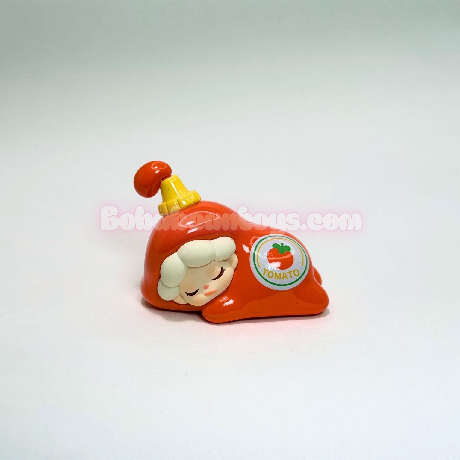 Small toy figure of a character dressed as ketchup on a light gray background