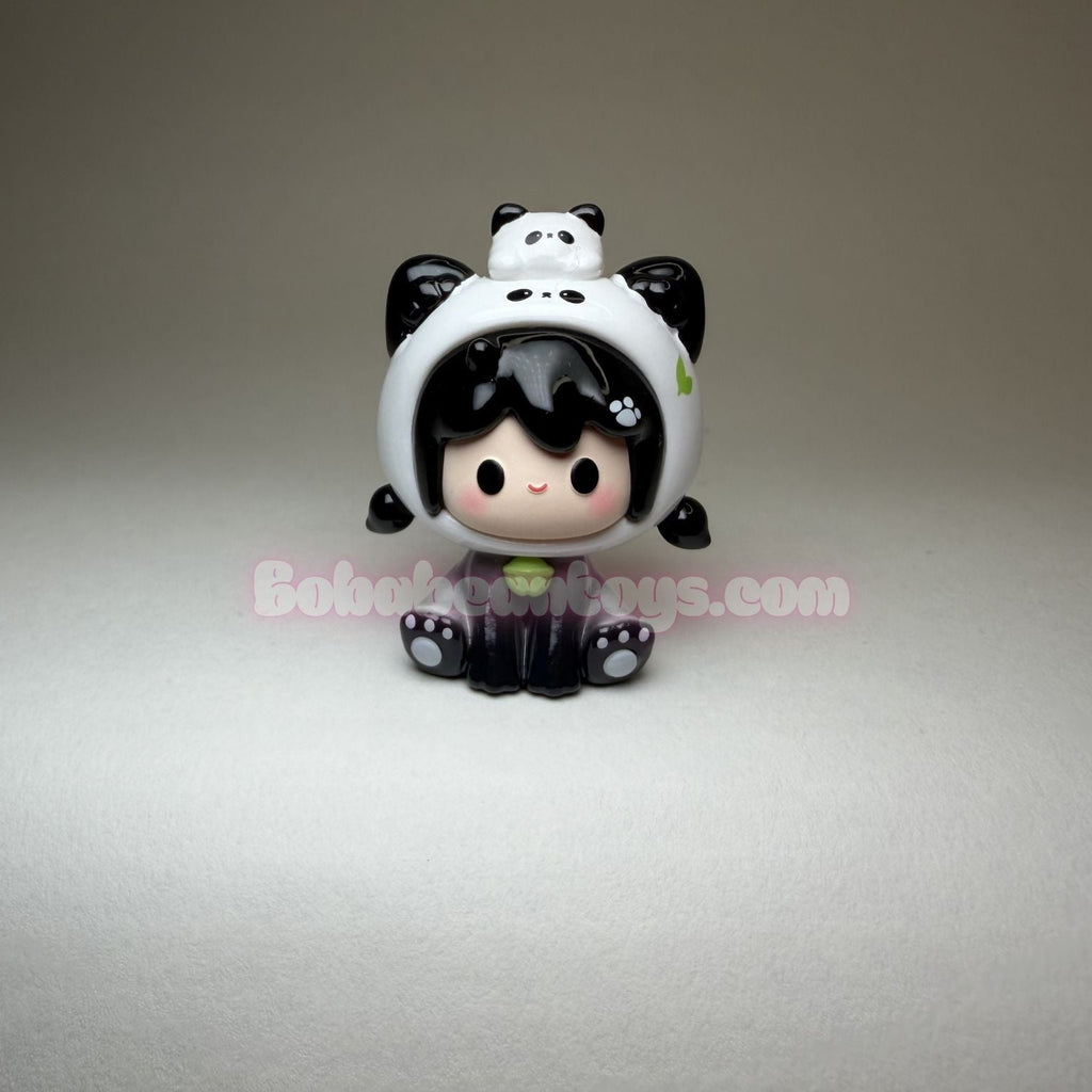 Toy figure of a character wearing a panda hat on a gray background