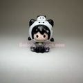 Toy figure of a character wearing a panda hat on a gray background