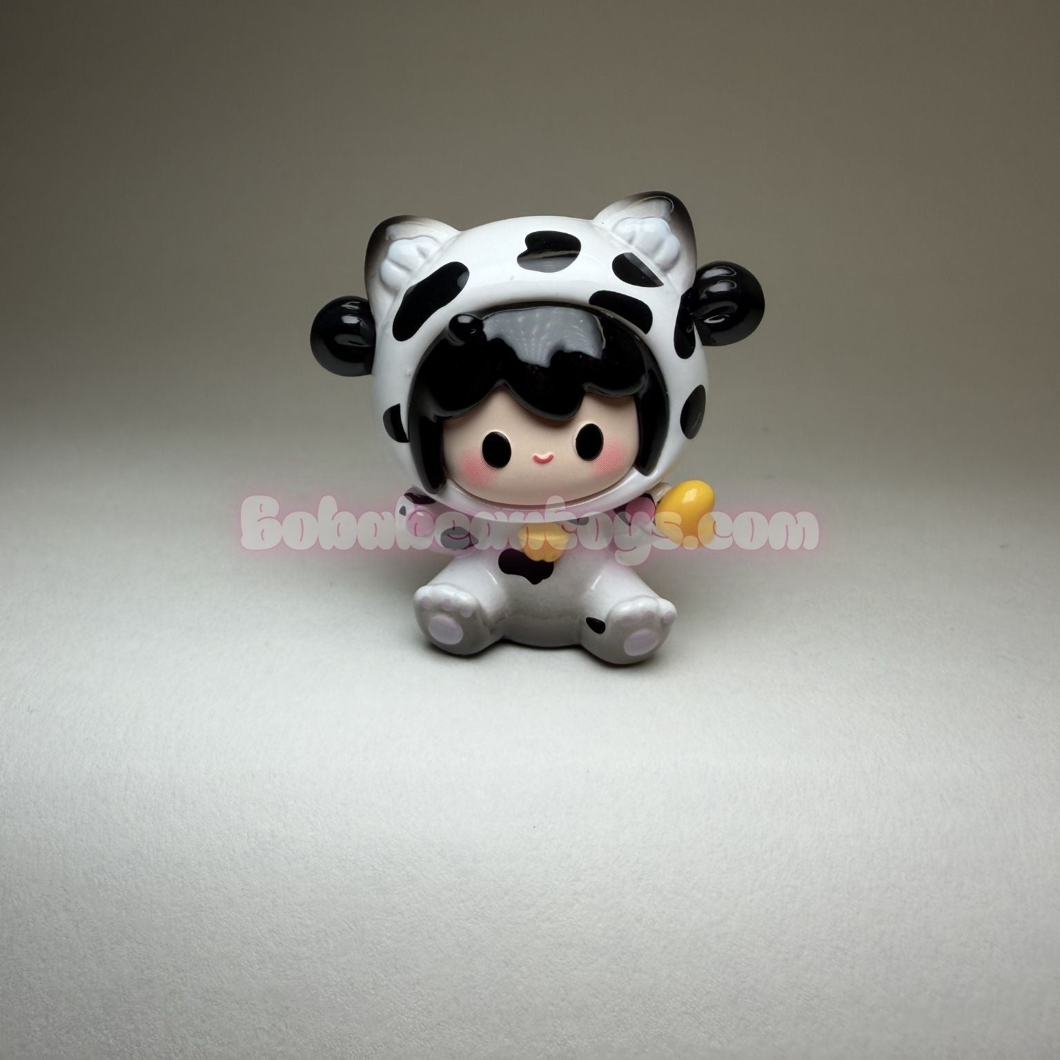 Small figurine of a character in a cow costume on a gray background