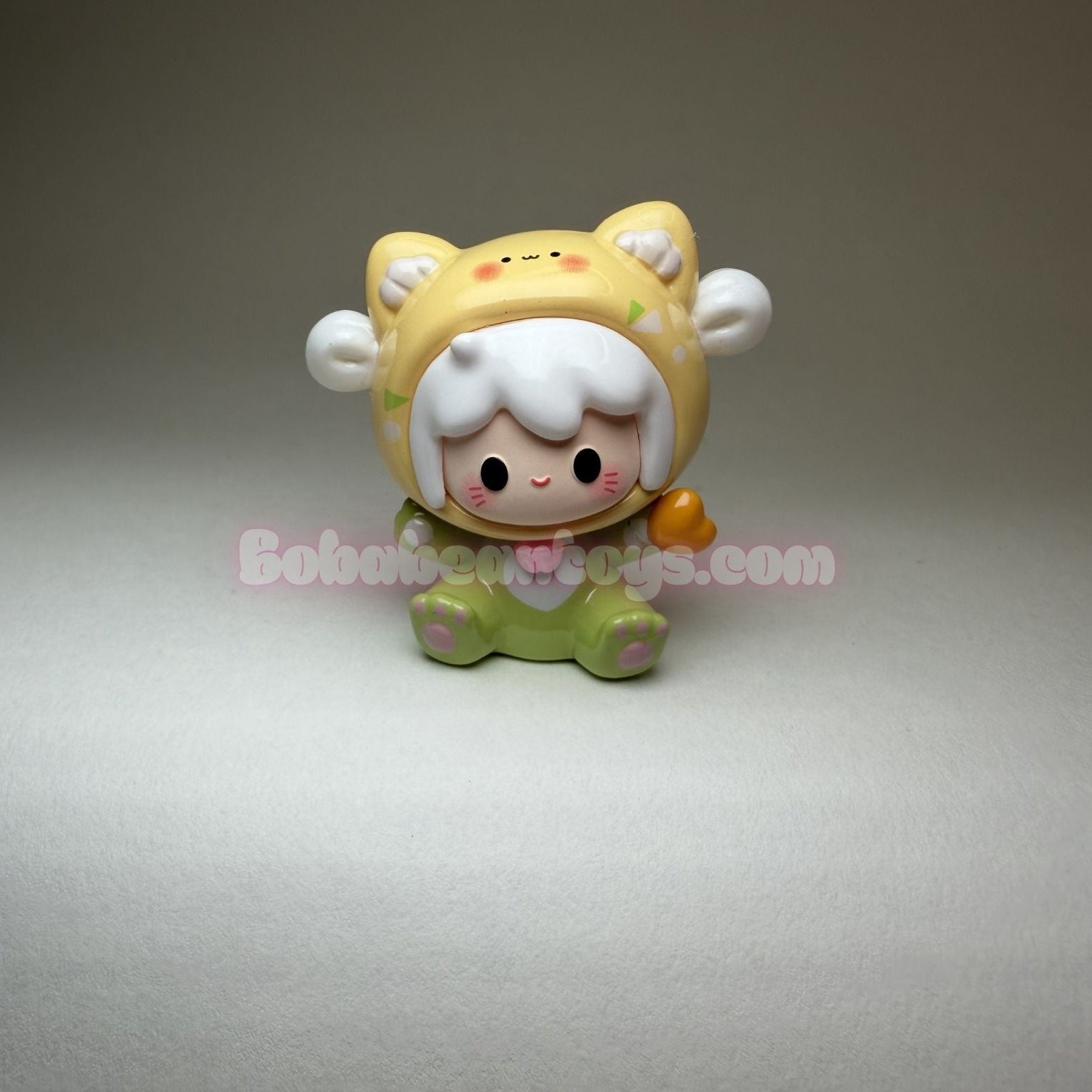 Small figurine with a yellow hat and green outfit on a gray background