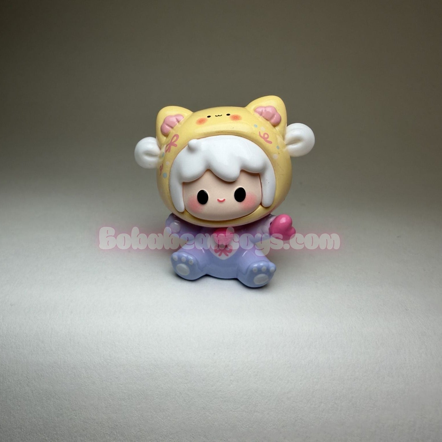 Cute character figurine with a light-colored hat and purple outfit on a gray background