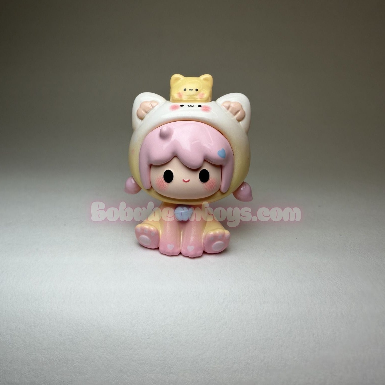 Kawaii-style figurine with pink hair and cat ears on a gray background