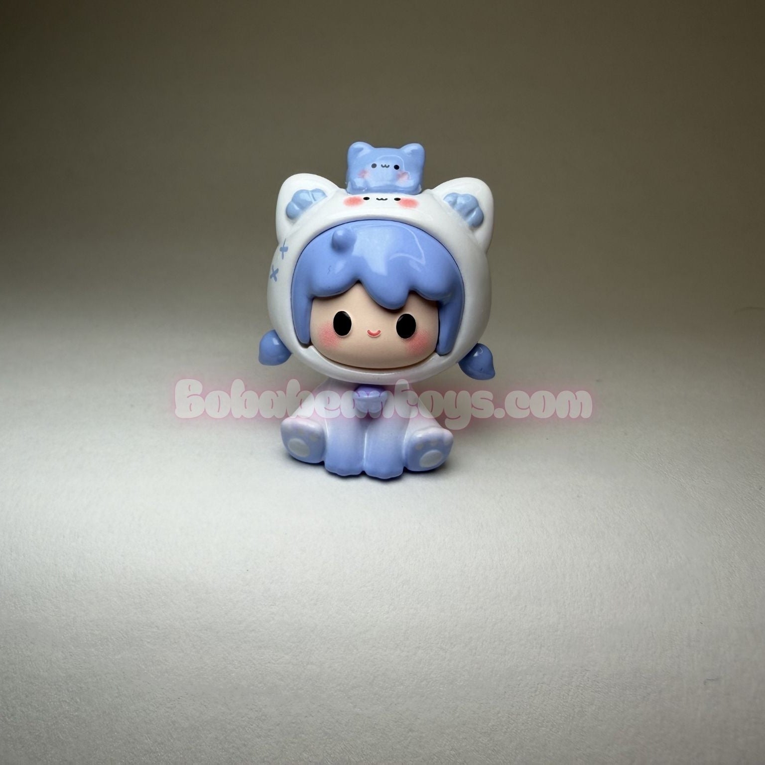Small blue and white character figurine on a gray background