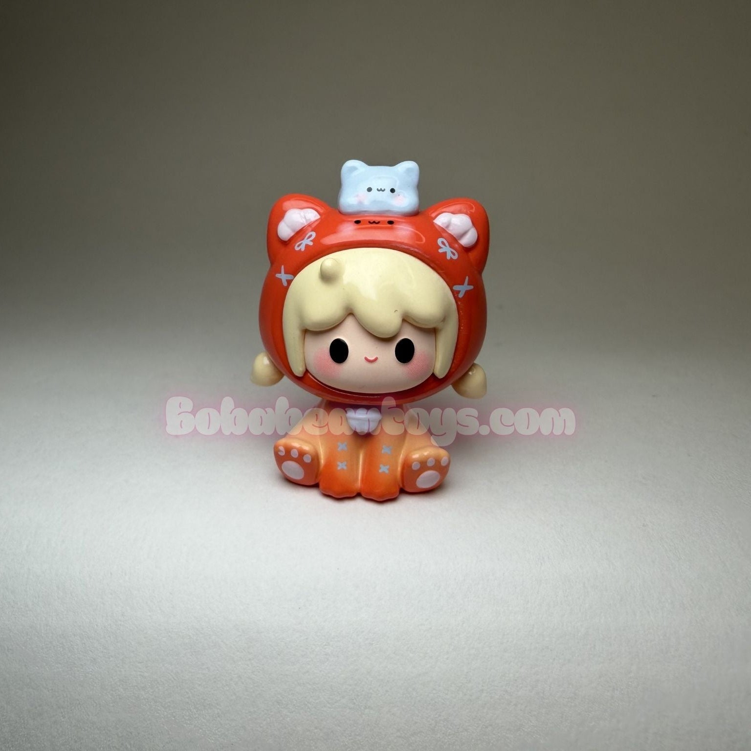 Small figurine with a red outfit and white headband on a gray background