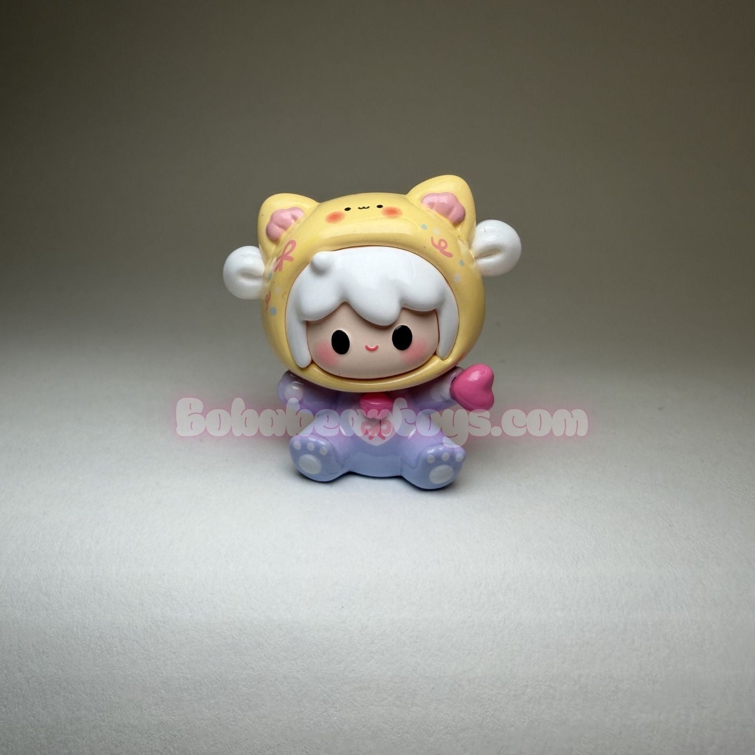 Cartoon character figurine with a yellow hat on a gray background