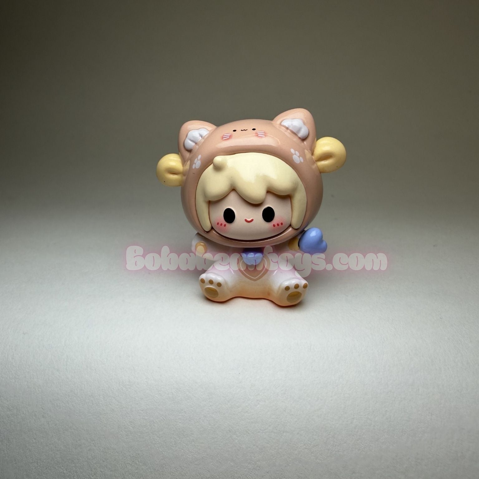 Small figurine with a brown hood and yellow accents on a gray background
