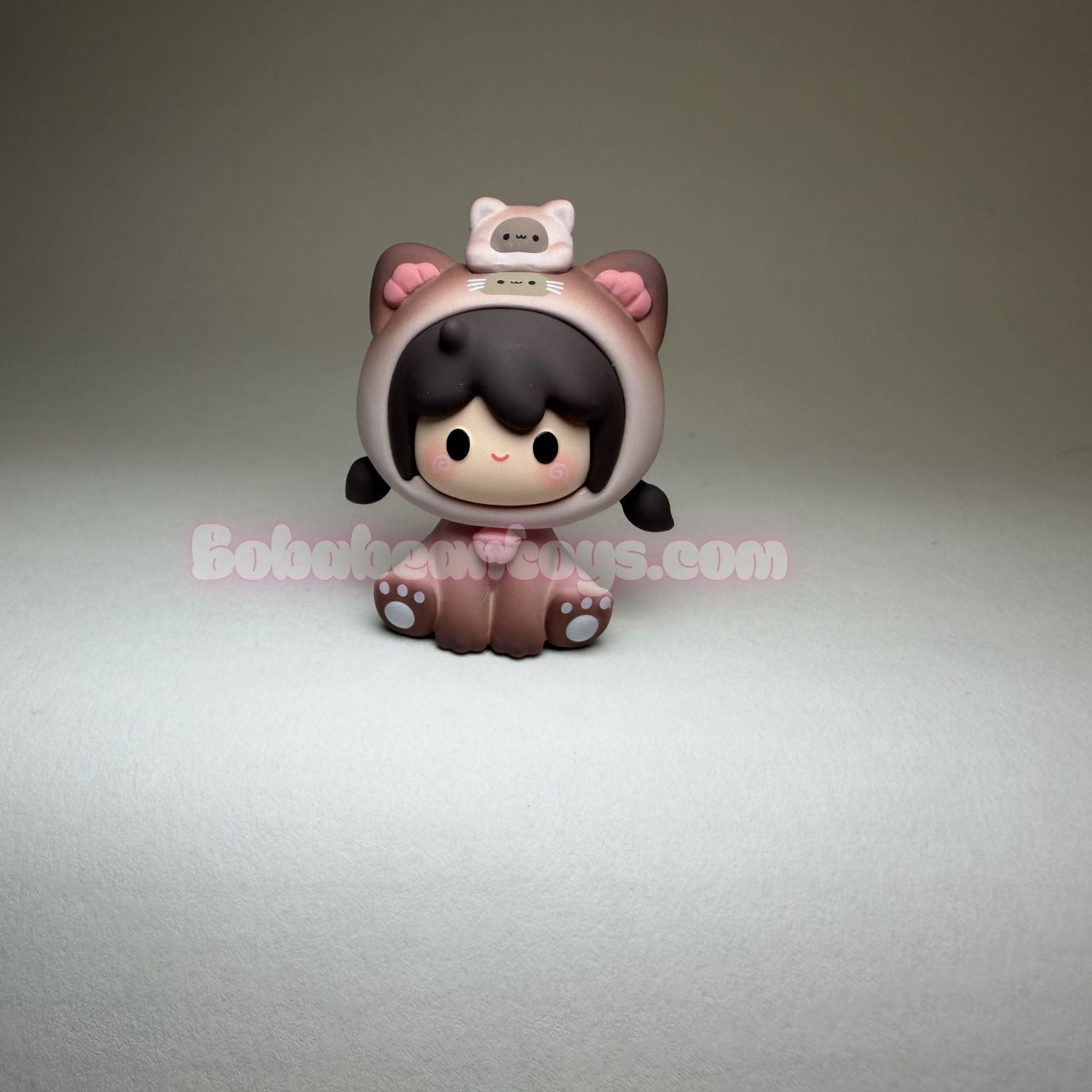 Small figurine with cat ears on a gray background