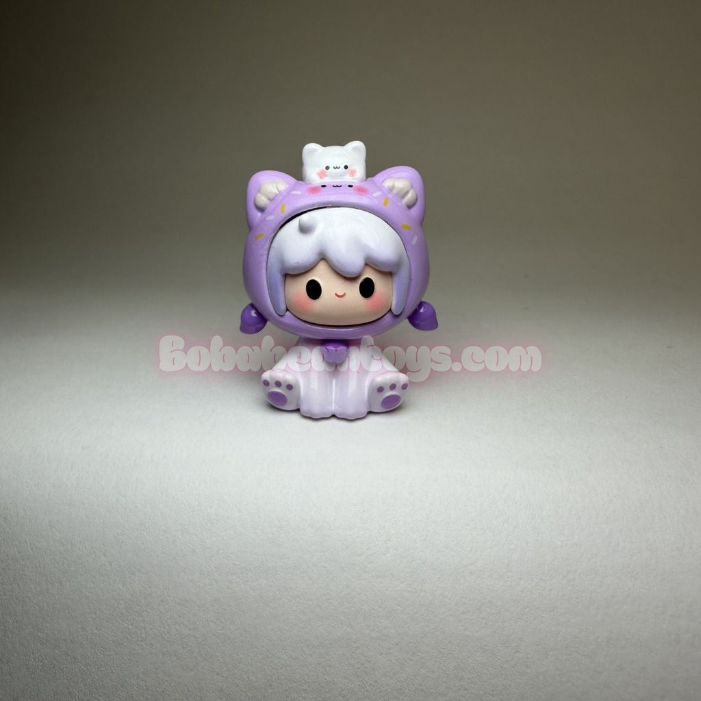 Small figurine with a purple outfit on a gray background