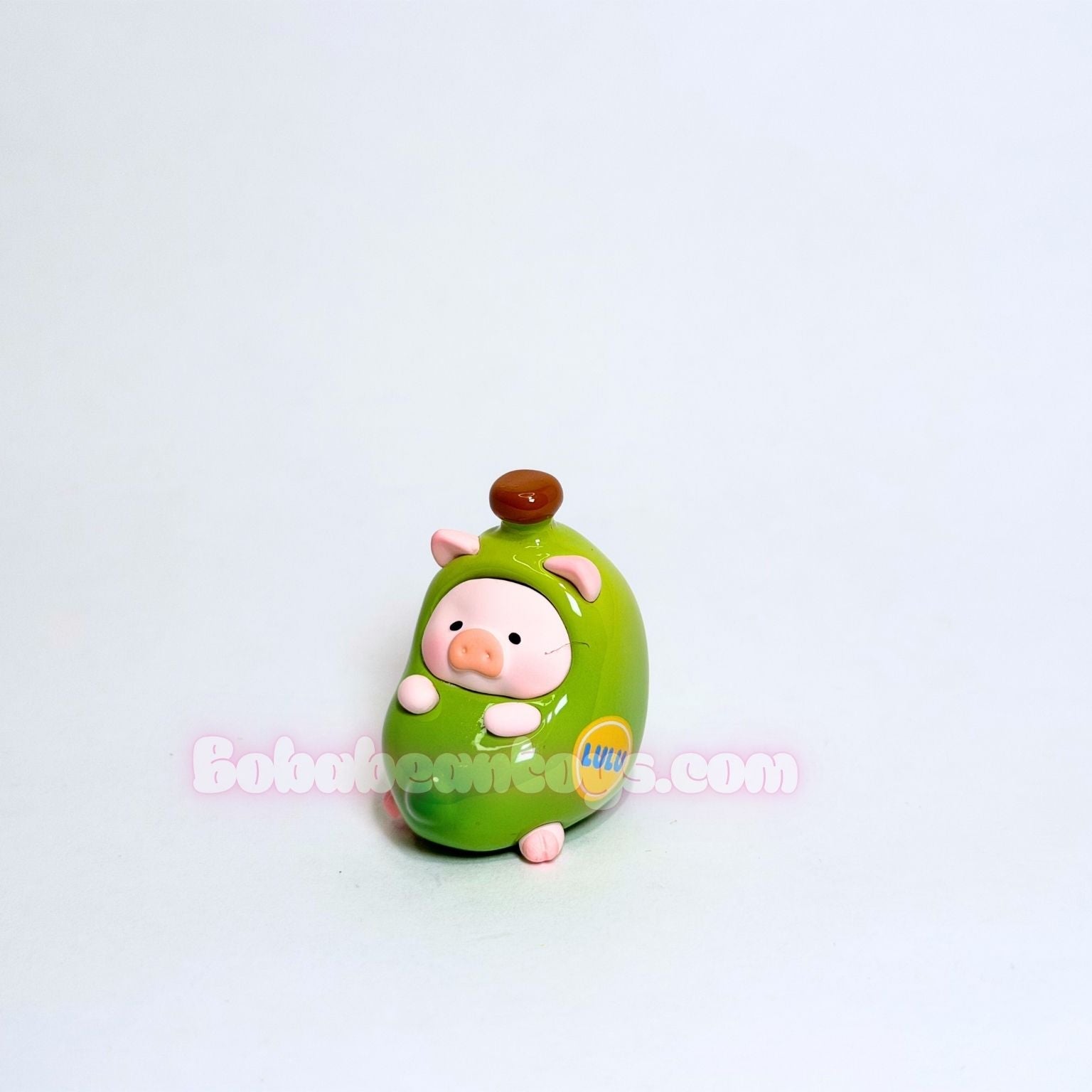 Green pig shaped as a banana on a white background